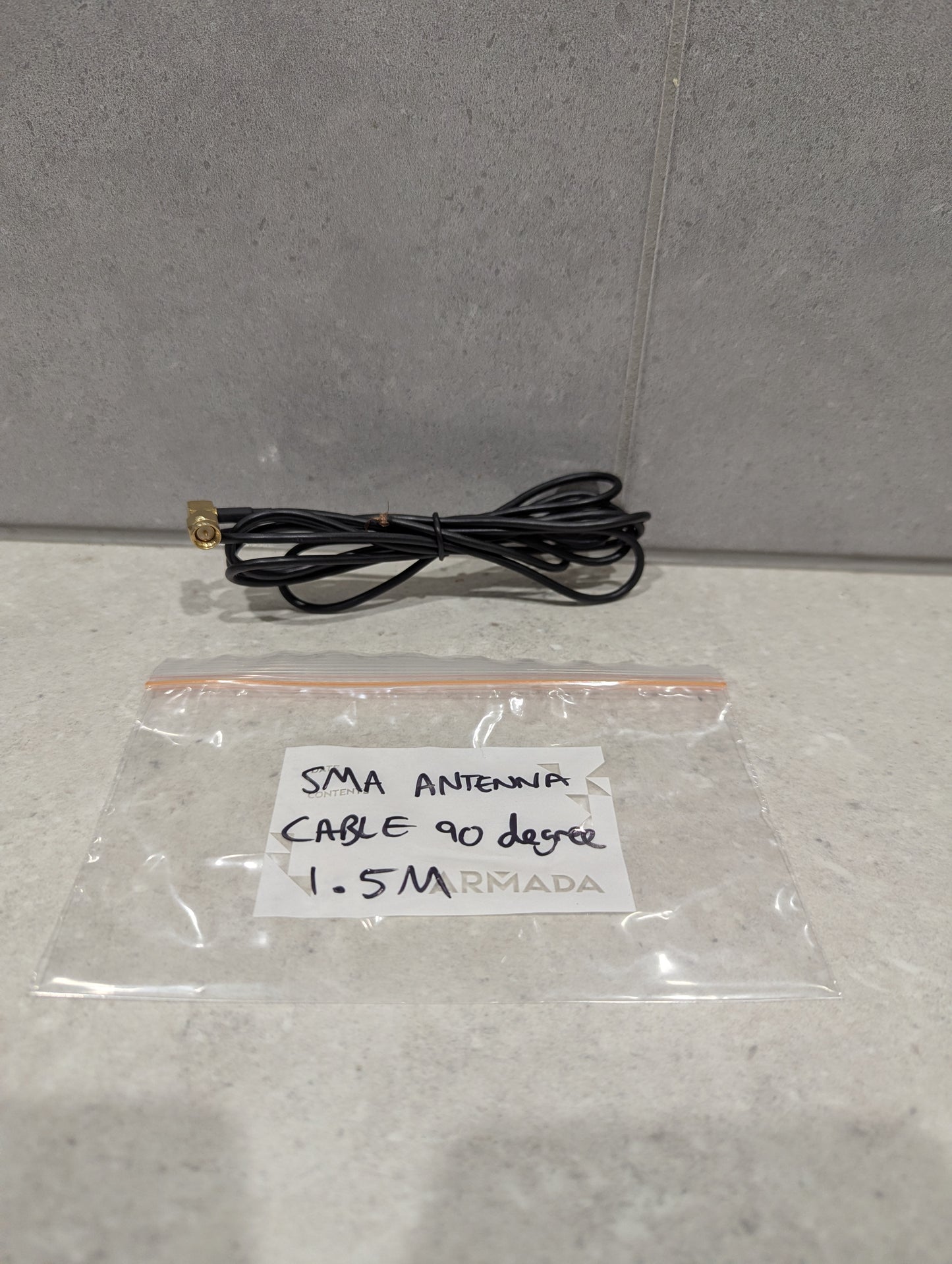 SMA antenna cable with 90-degree connector and 1.5 meter length in front of labeled storage bag
