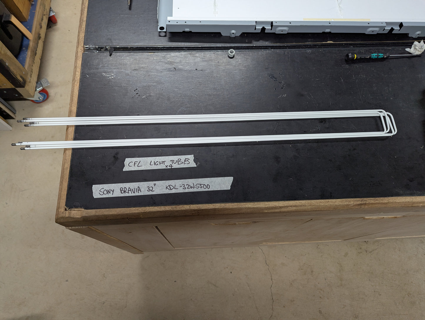 Set of four CFL light tubes for Sony Bravia 32 inch KDL-32W5500 TV on a workbench