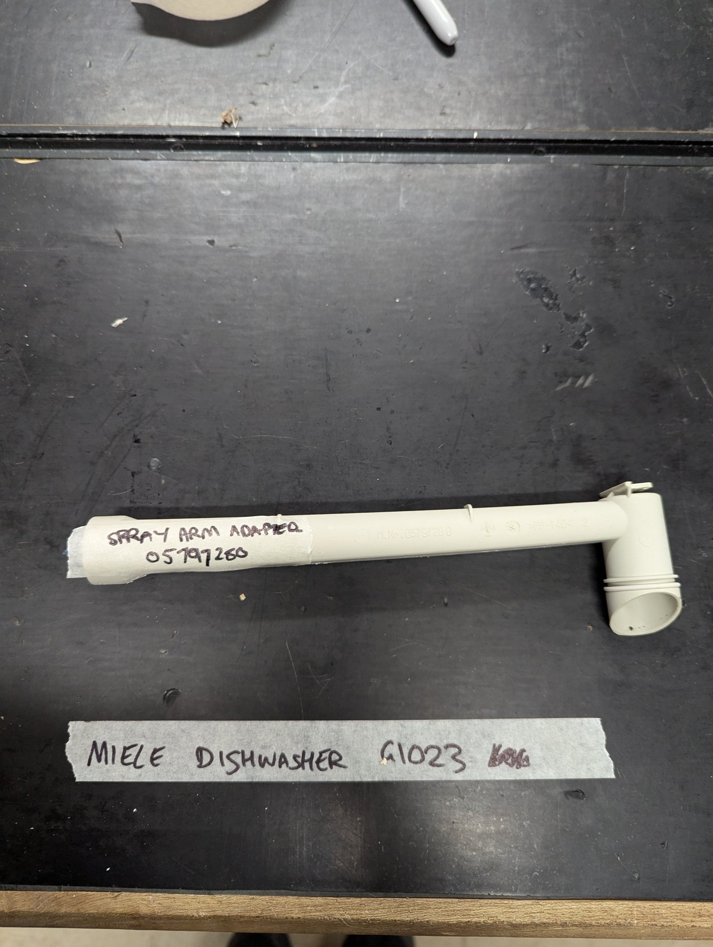 Miele G1023 dishwasher spray arm adapter on black surface