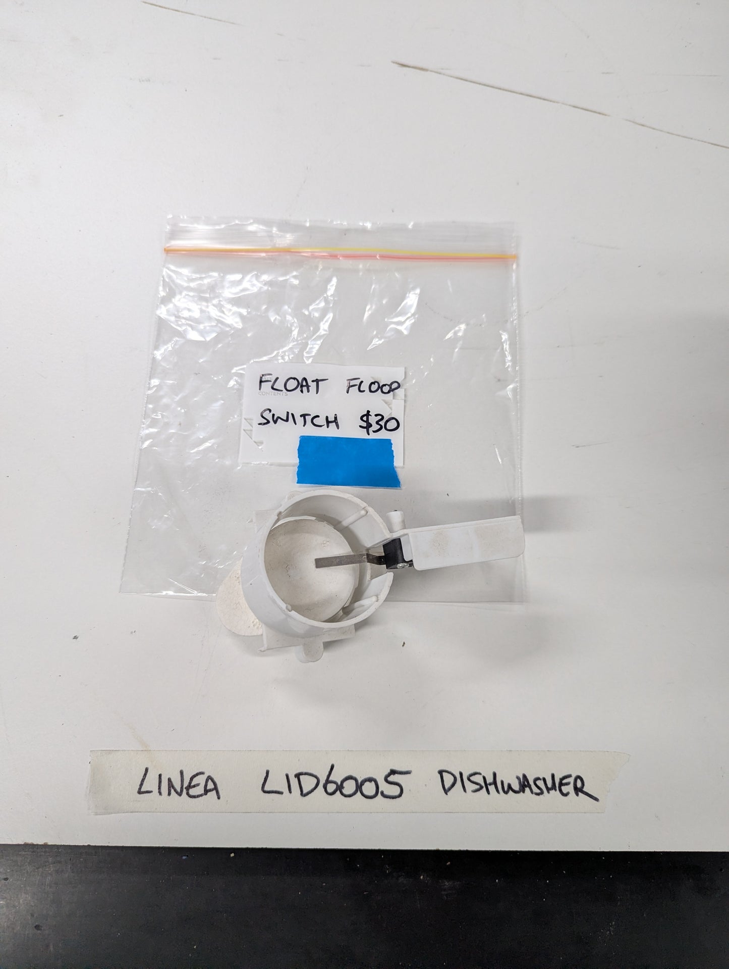 Linea LID6005 dishwasher float flood switch on a white surface with labeled bag
