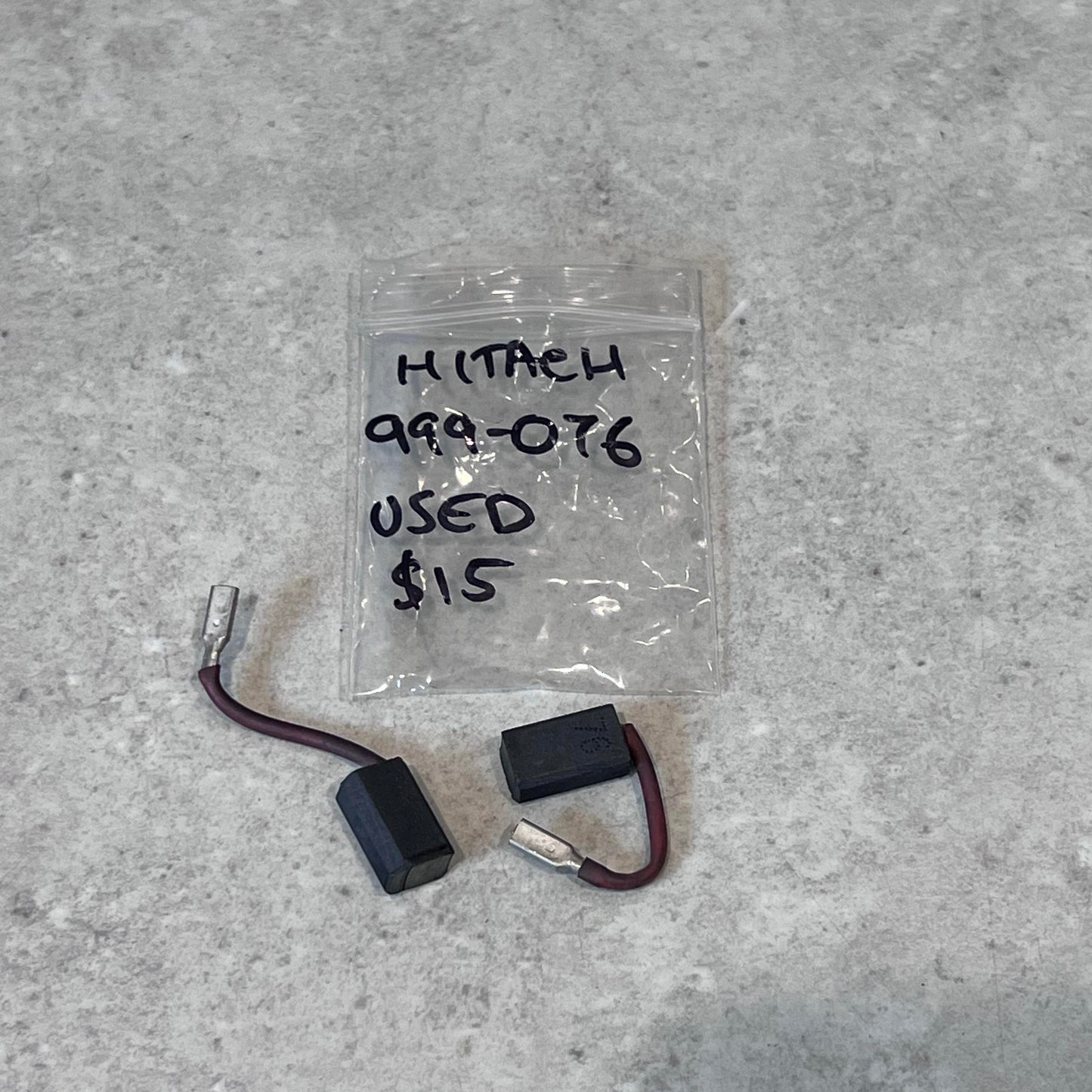Used Hitachi 999-076 carbon brush pair with wire leads and labeled plastic bag