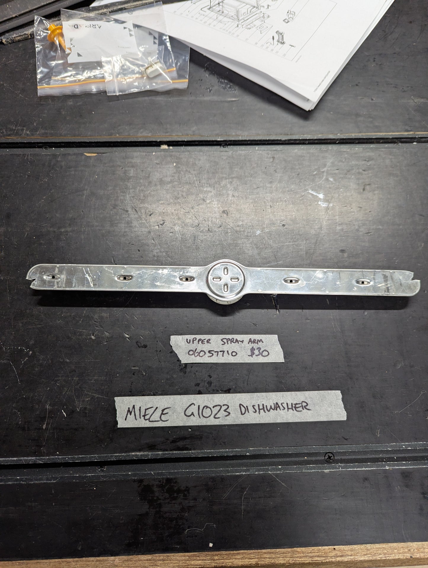 Miele G1023 dishwasher upper spray arm replacement part displayed on table