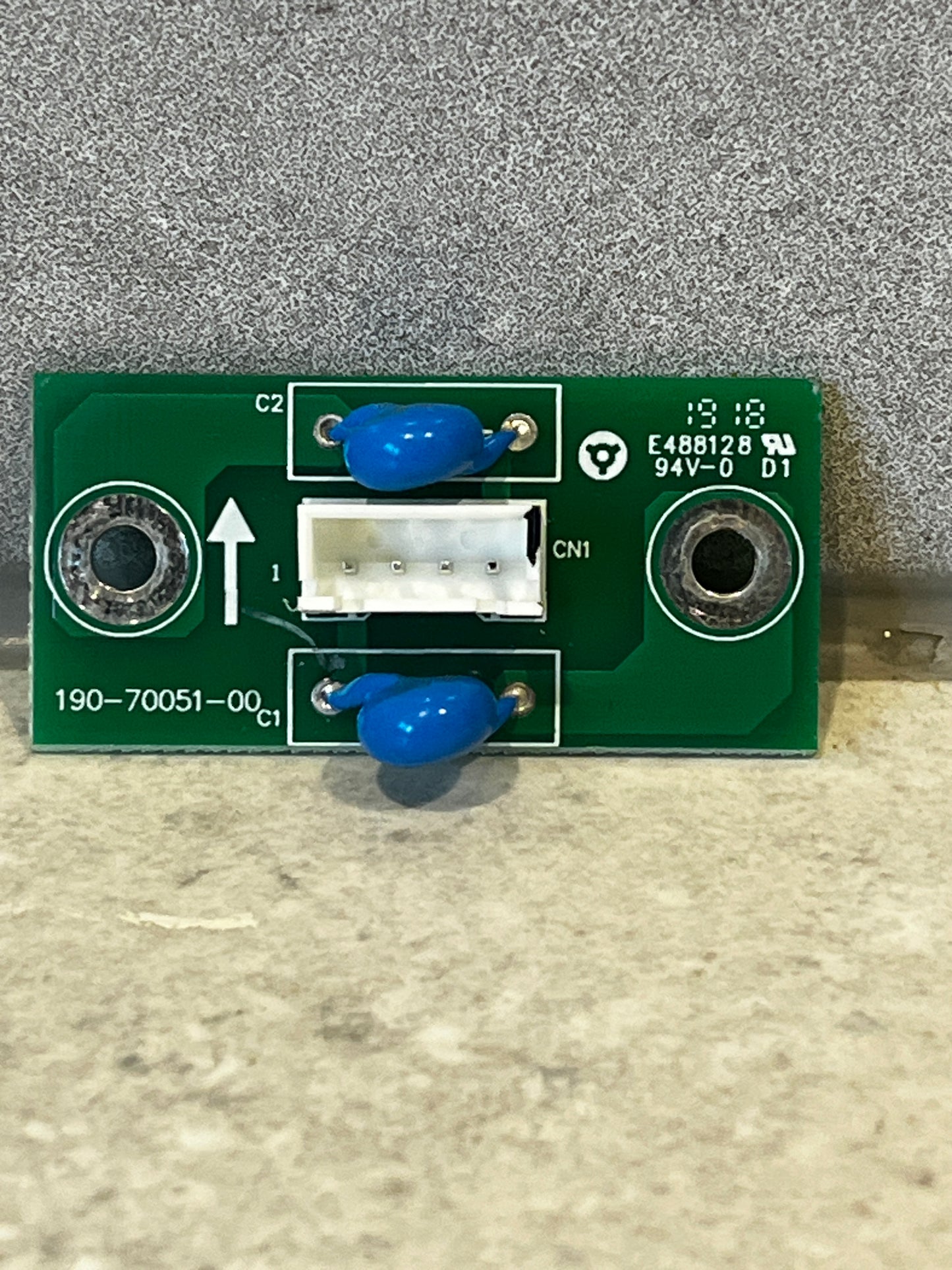 Rectangular green printed circuit board with blue components and white connector