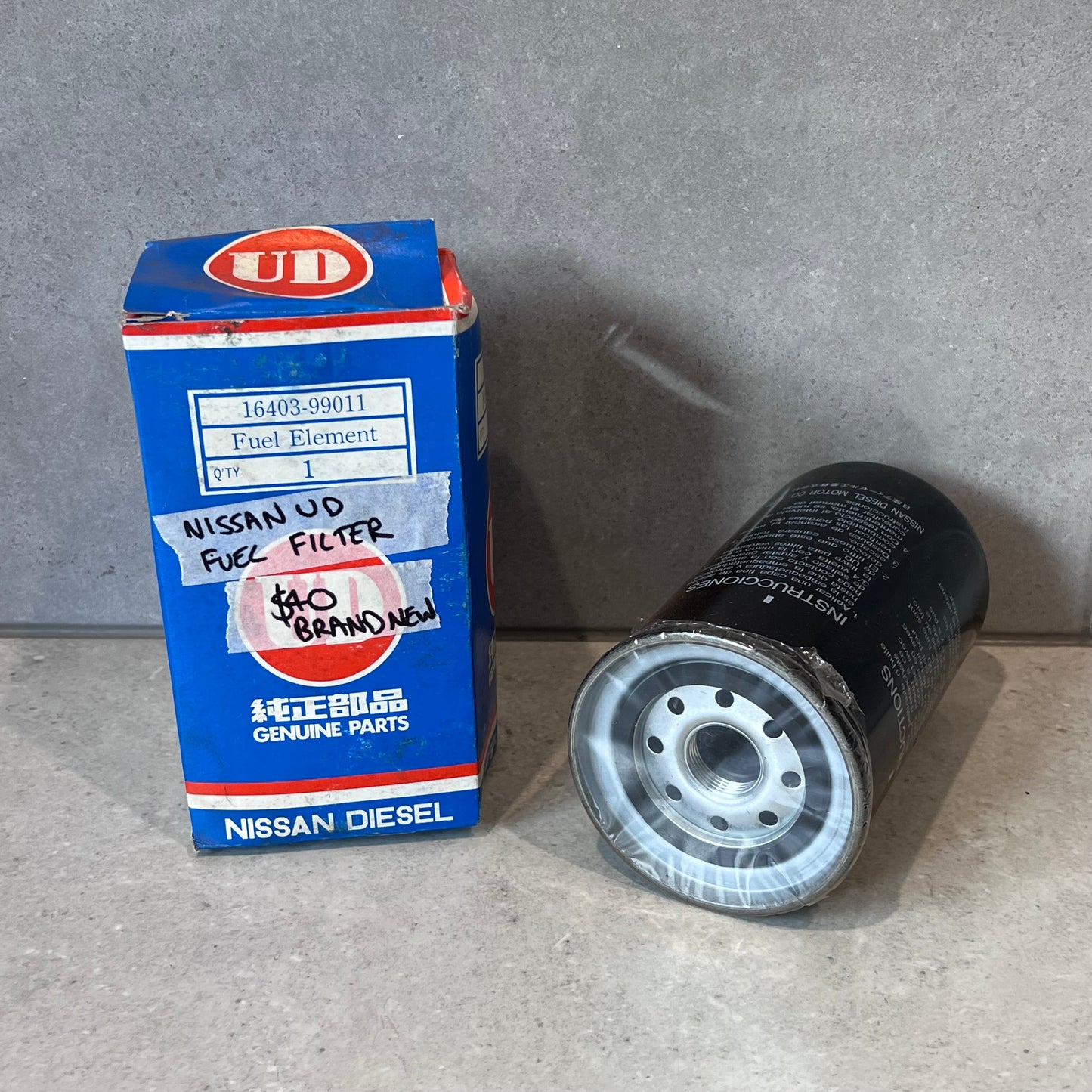 Box and brand new Nissan UD genuine diesel fuel filter with part number 16403-99011