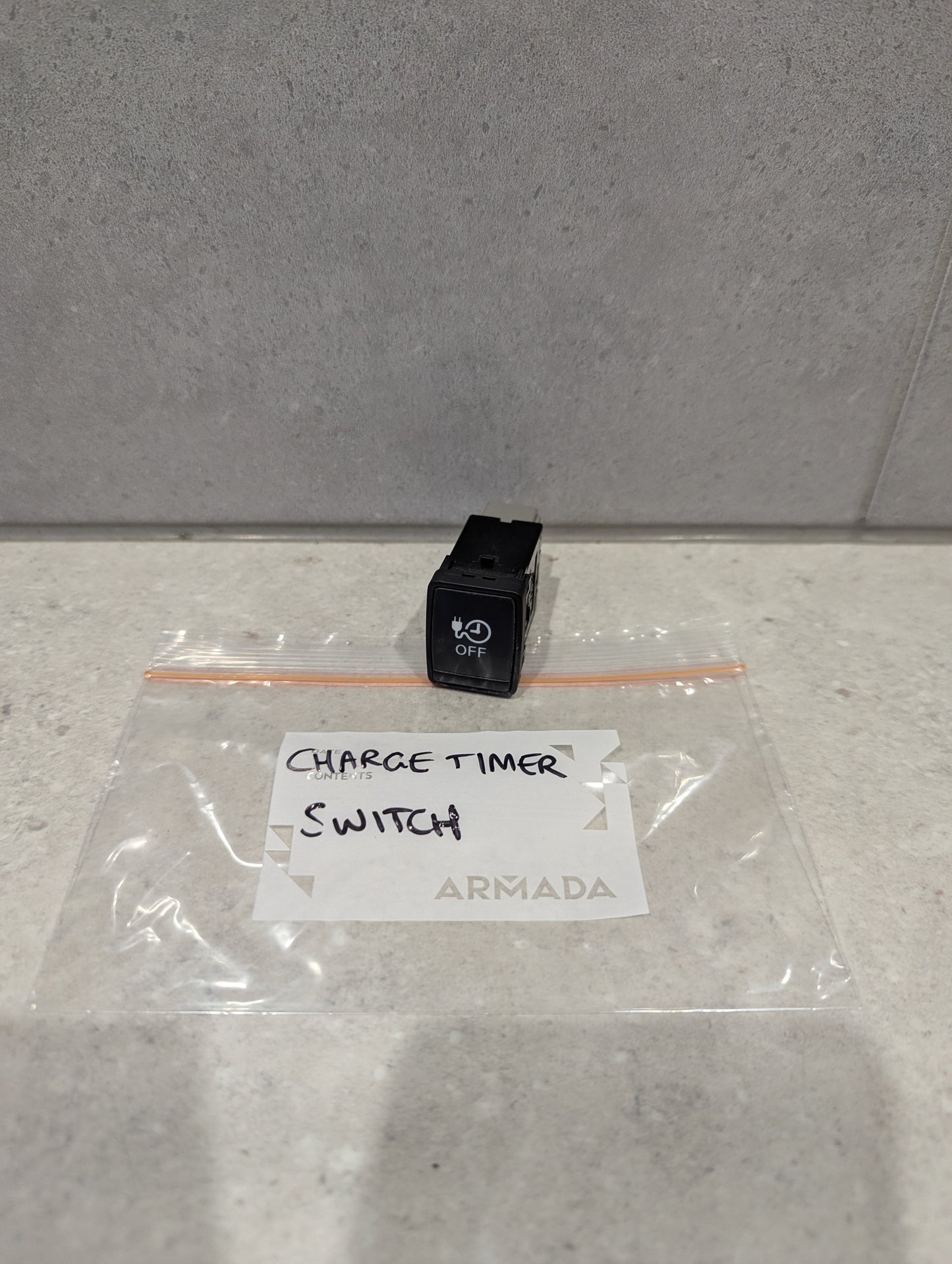 Armada black charge timer switch on a counter in a labeled plastic bag
