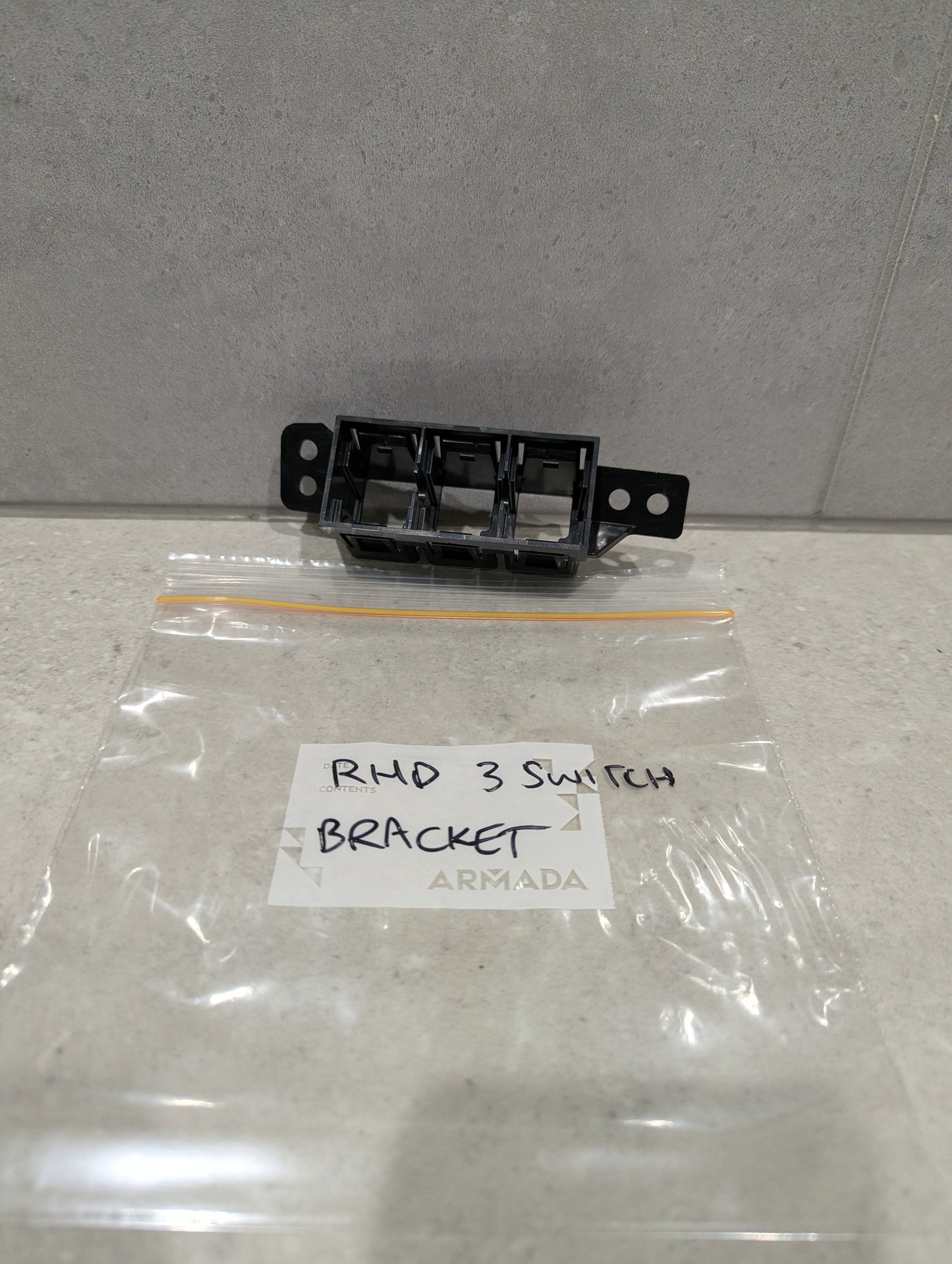 Armada RHD 3 switch bracket with labeled plastic bag on stone surface