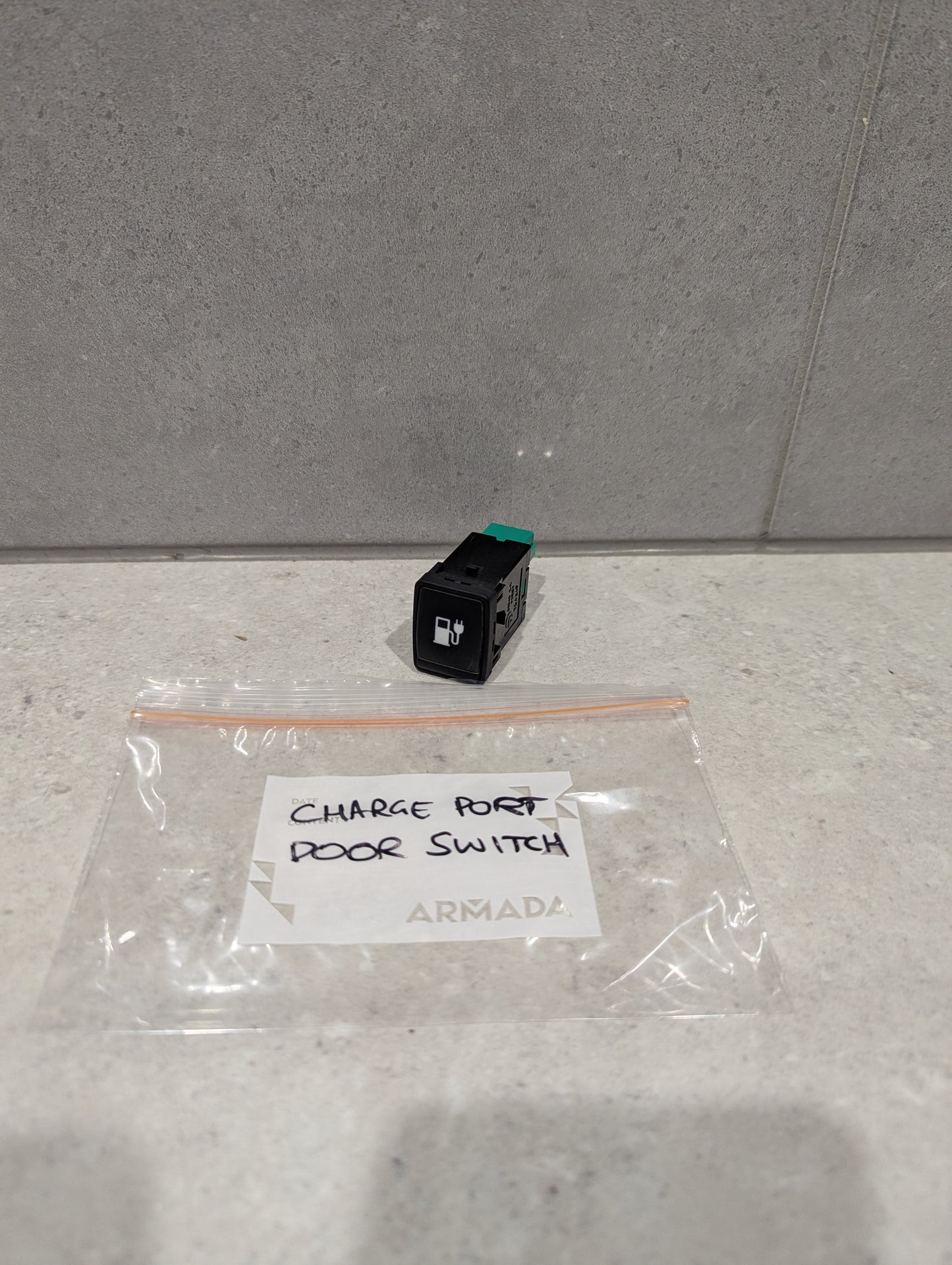 Charge port door switch replacement on countertop with labeled plastic bag