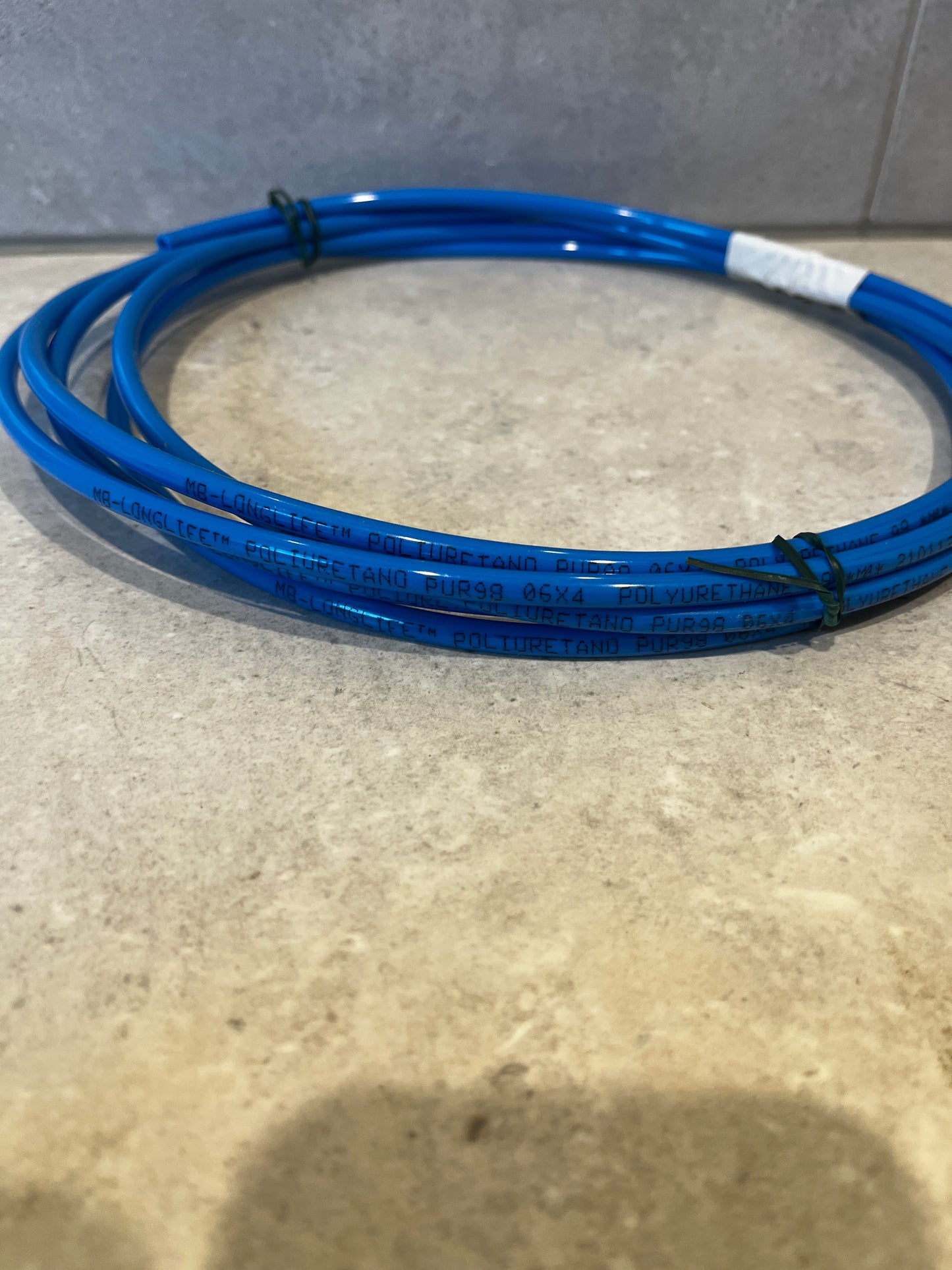 Close-up of blue polyurethane tubing coil with printed label and wire ties