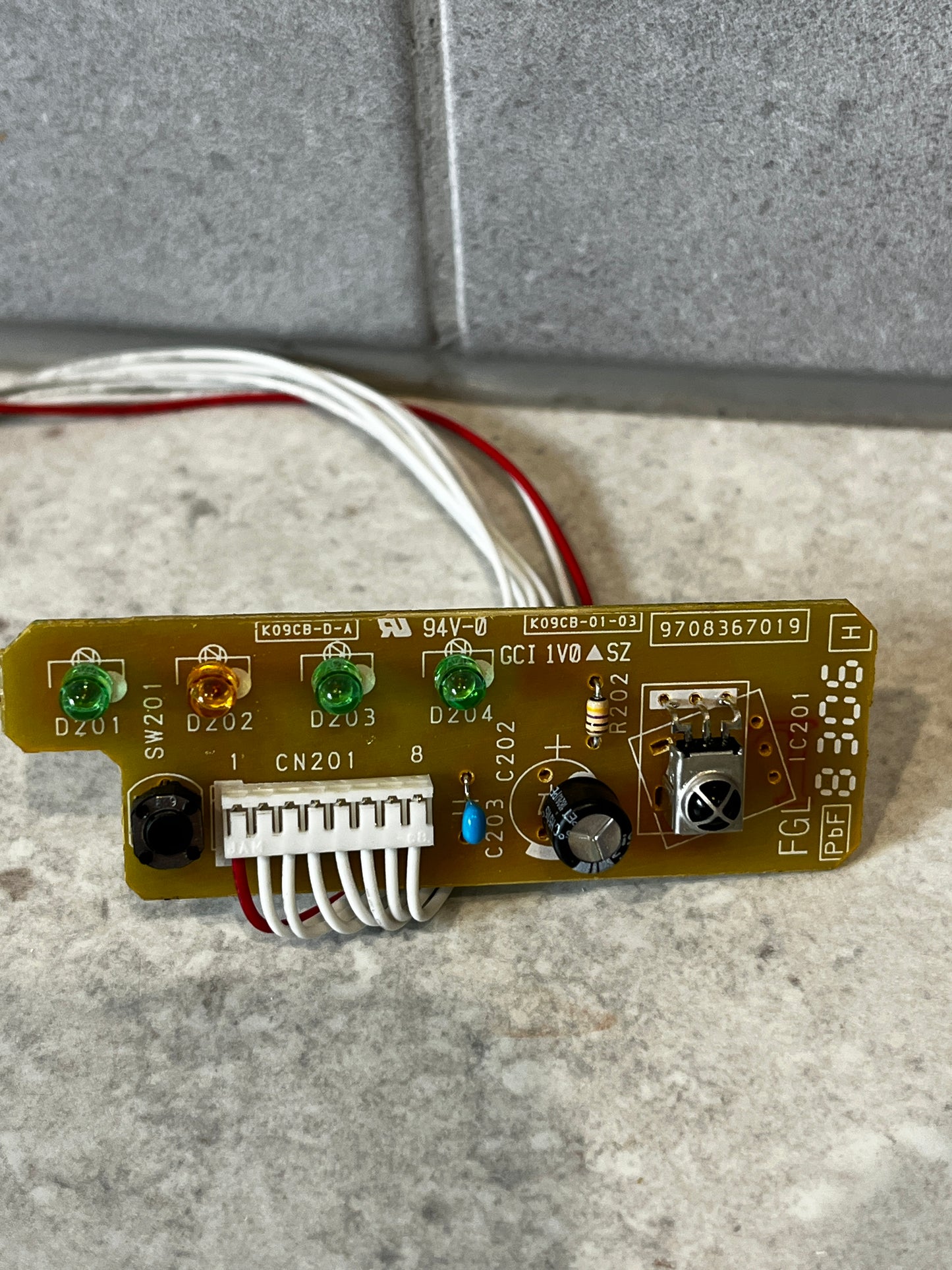 Close-up view of electronic circuit board module showing LEDs, push button, and connector