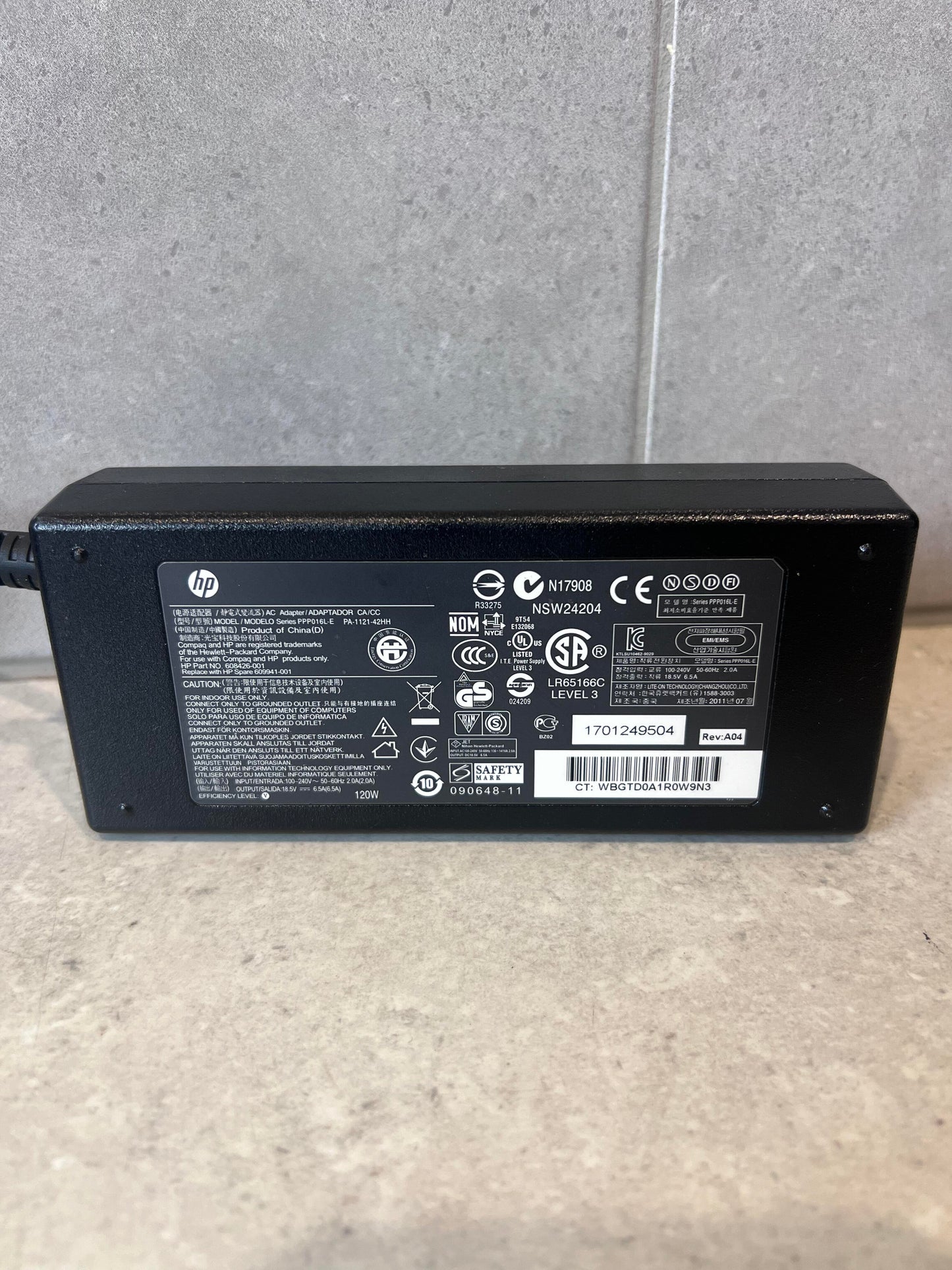 Close-up of label on HP 120W laptop power adapter showing specifications