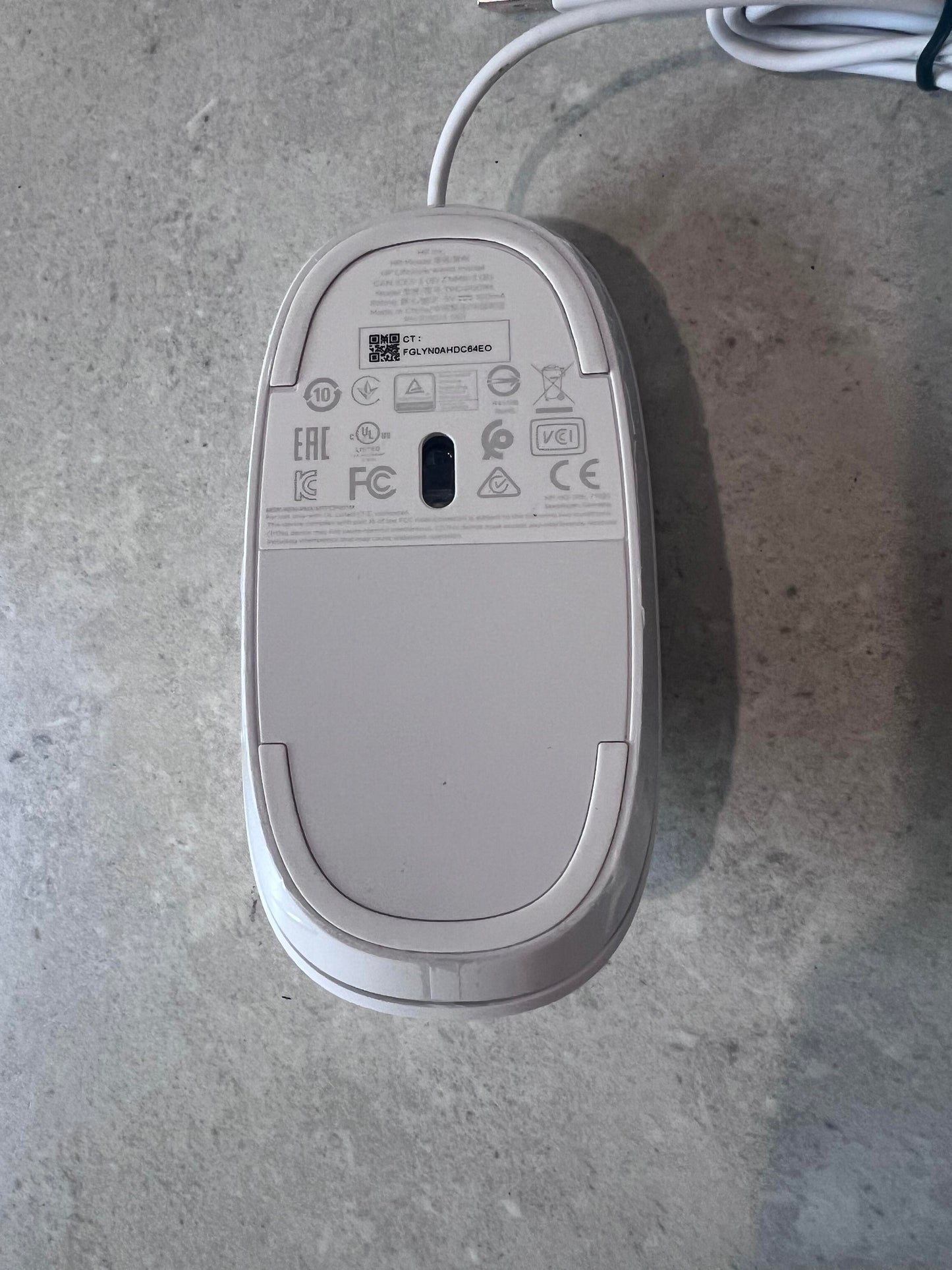 Bottom view of white HP optical mouse showing sensor and product labels