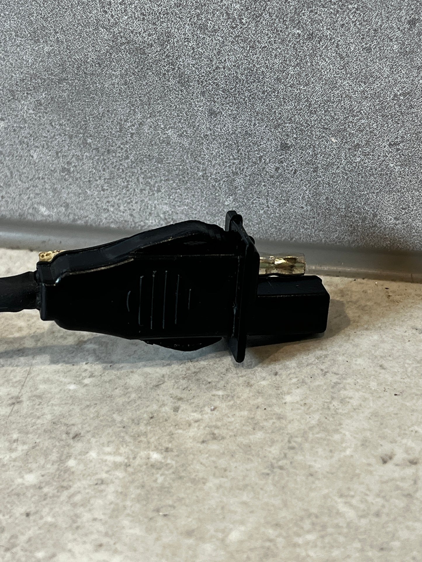 Close-up of automotive power adapter harness connector showing detail and metal contact