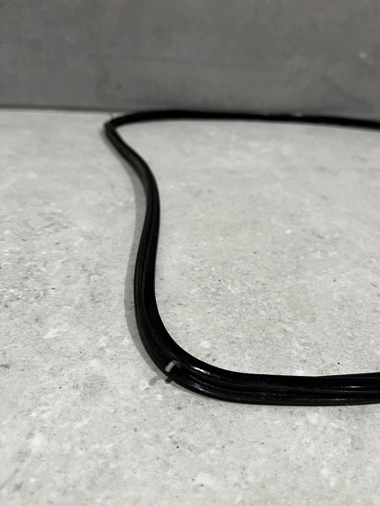 Close-up of black rubber window seal gasket corner showing texture and sealing grooves