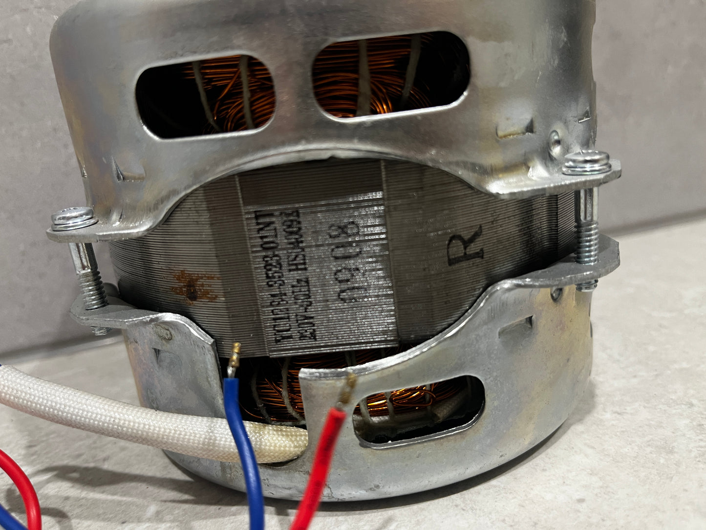 Close-up view of electric motor showing ventilation slots, metal frame, and wiring connections