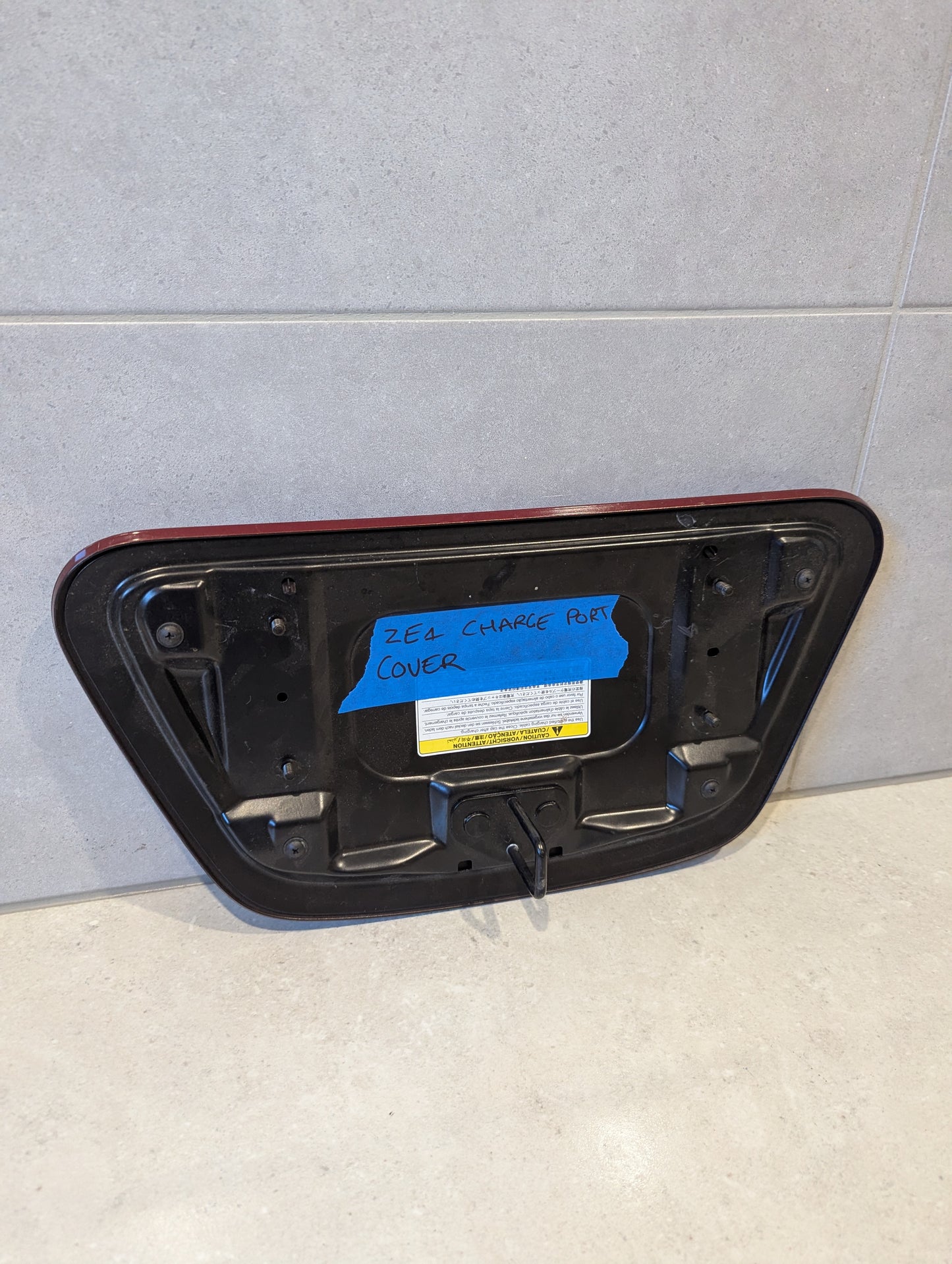Rear view of Nissan Leaf ZE1 charge port cover showing mounting points