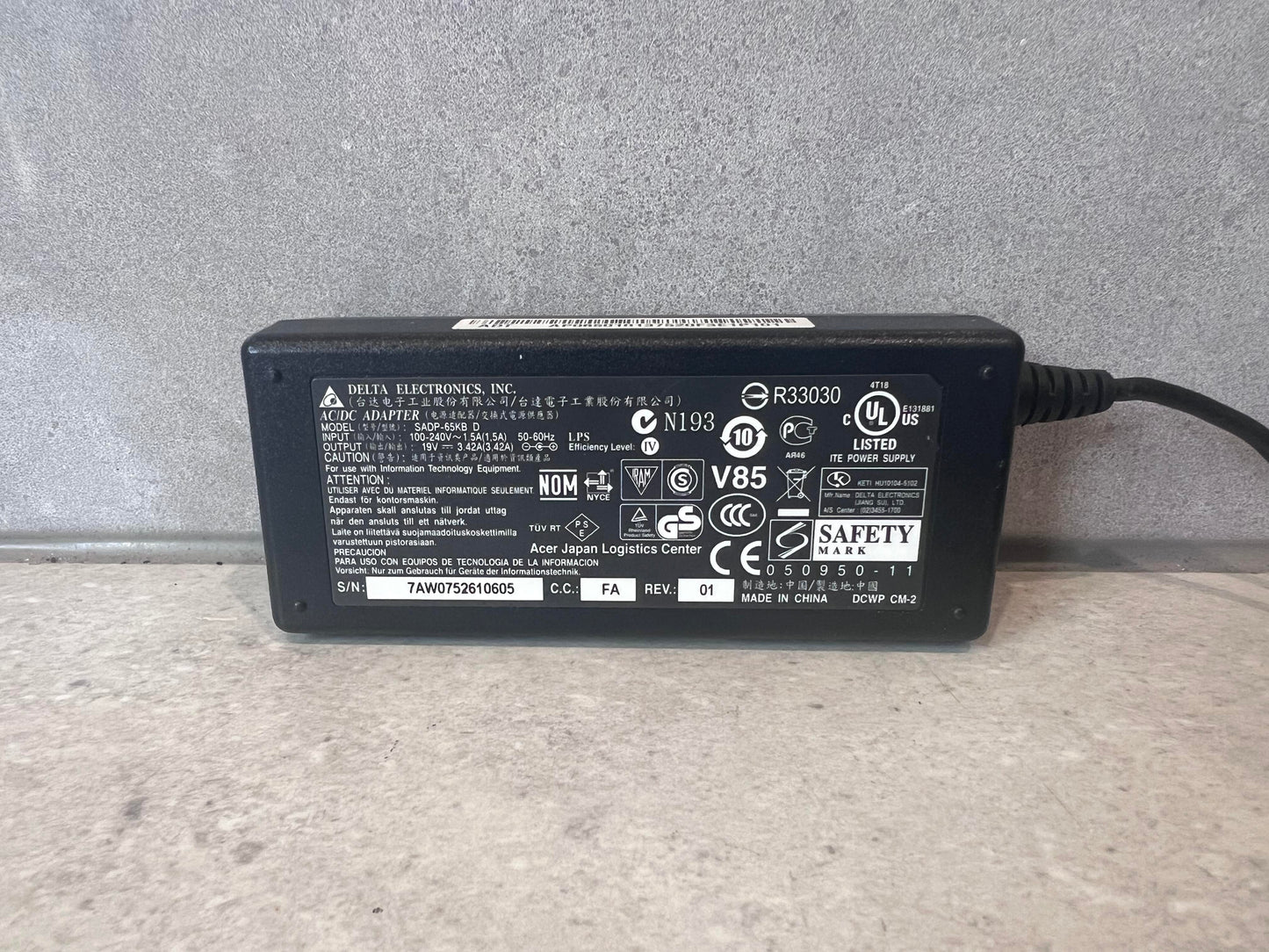 Close-up of Delta Electronics AC/DC adapter label with specifications