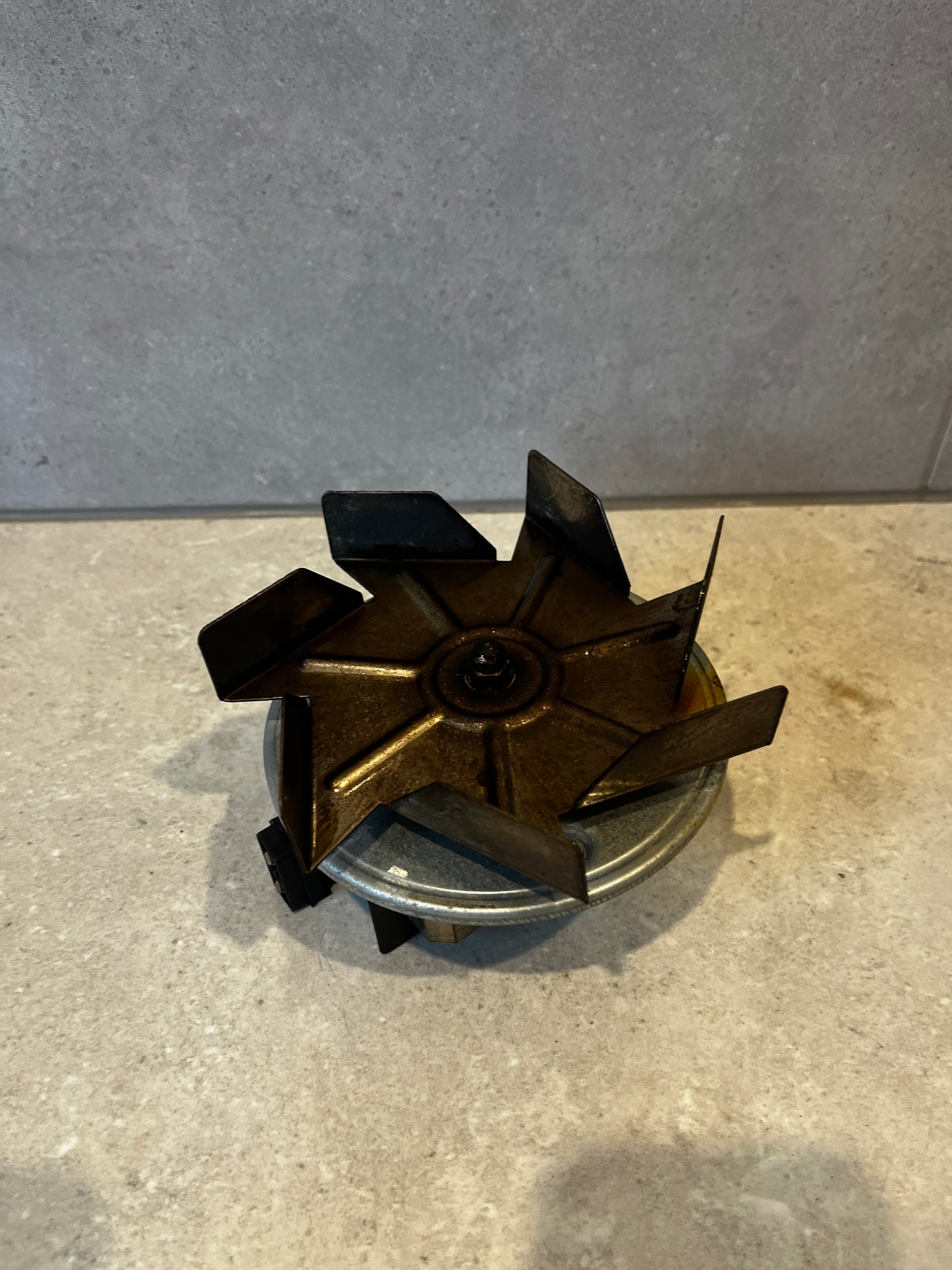 Top view of electric fan motor assembly showing angled metal blades
