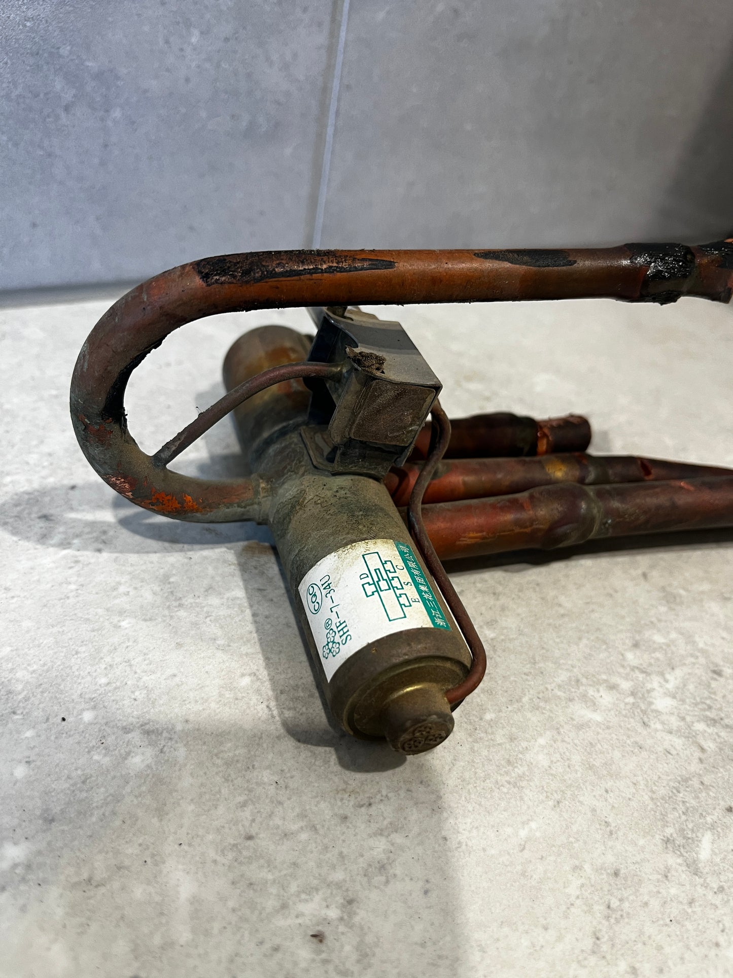 Close-up of copper refrigeration solenoid valve showing metal coil and electrical wiring