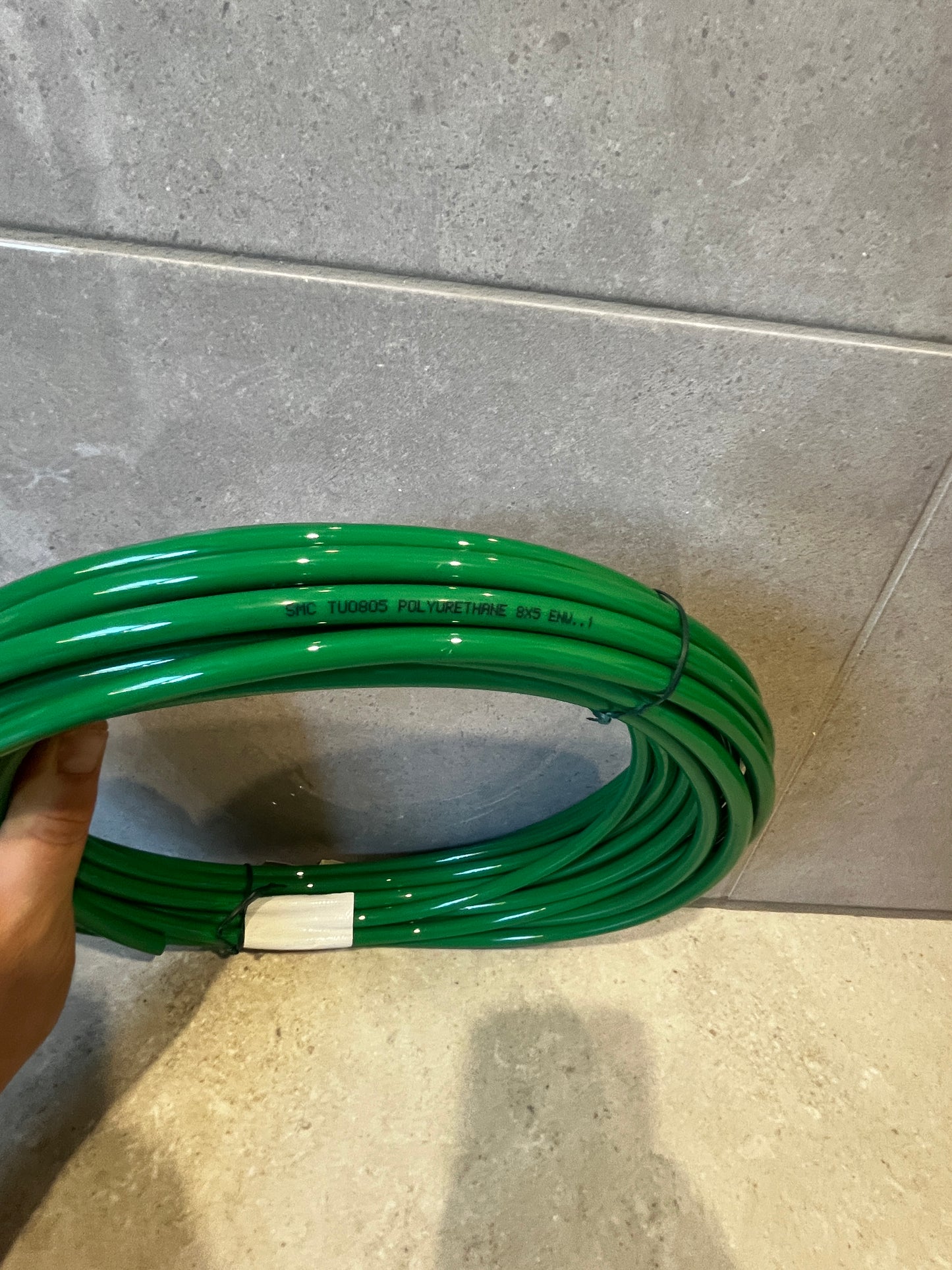 Close-up of green polyurethane tubing with product text printed on surface