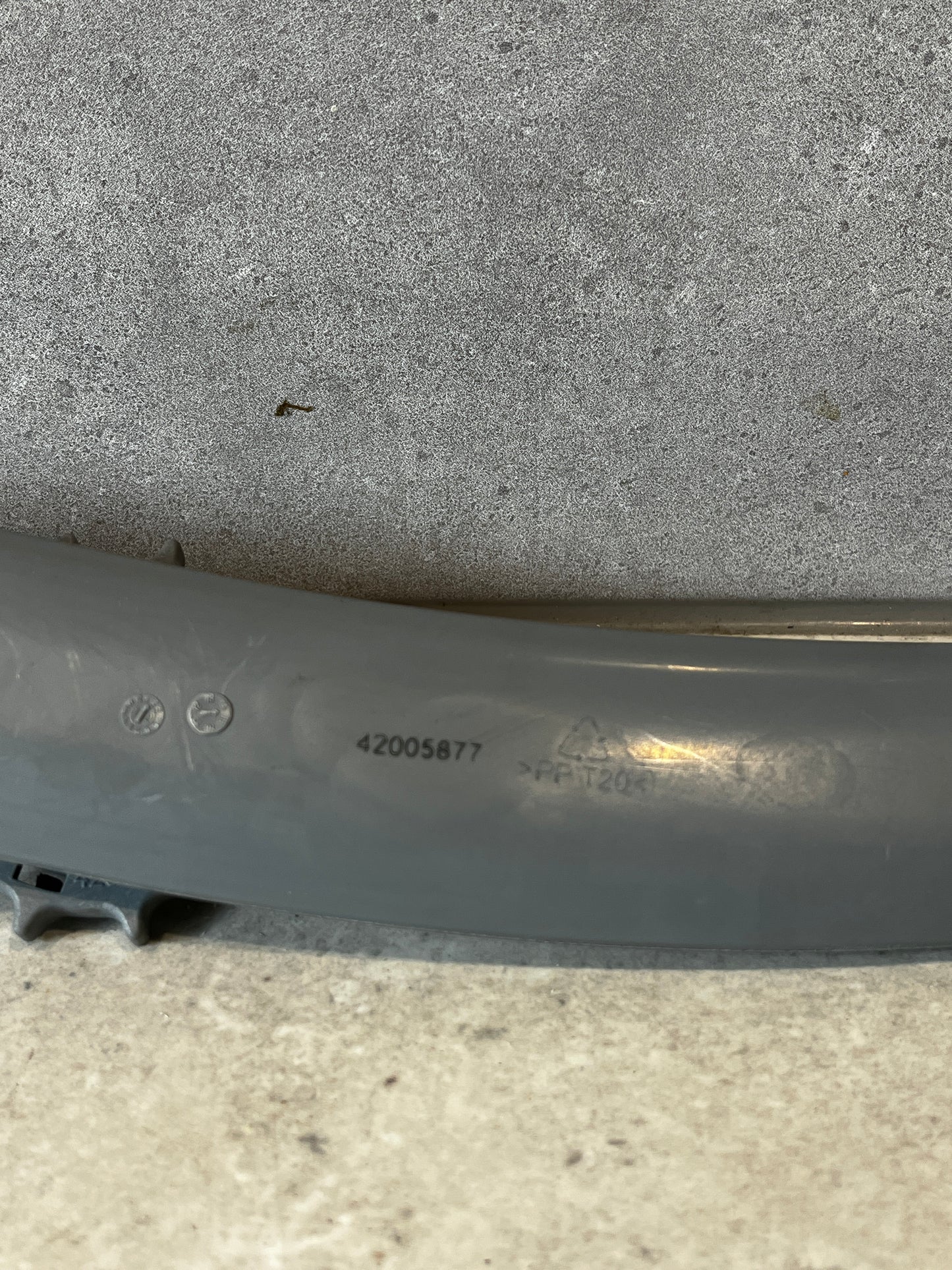 Close-up of grey plastic part showing product code and markings