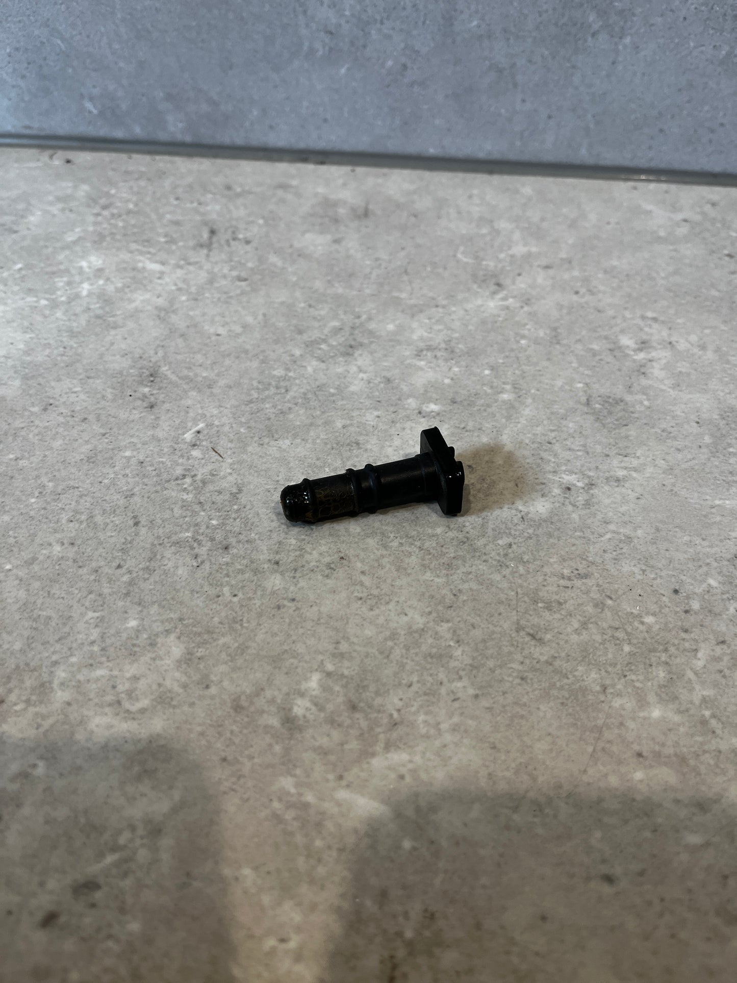Black automotive injector valve on a countertop