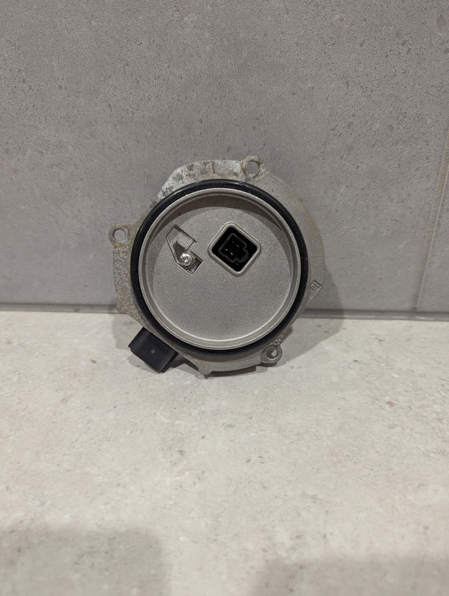Back view of Ichikoh LED headlight control module showing circular housing and connector