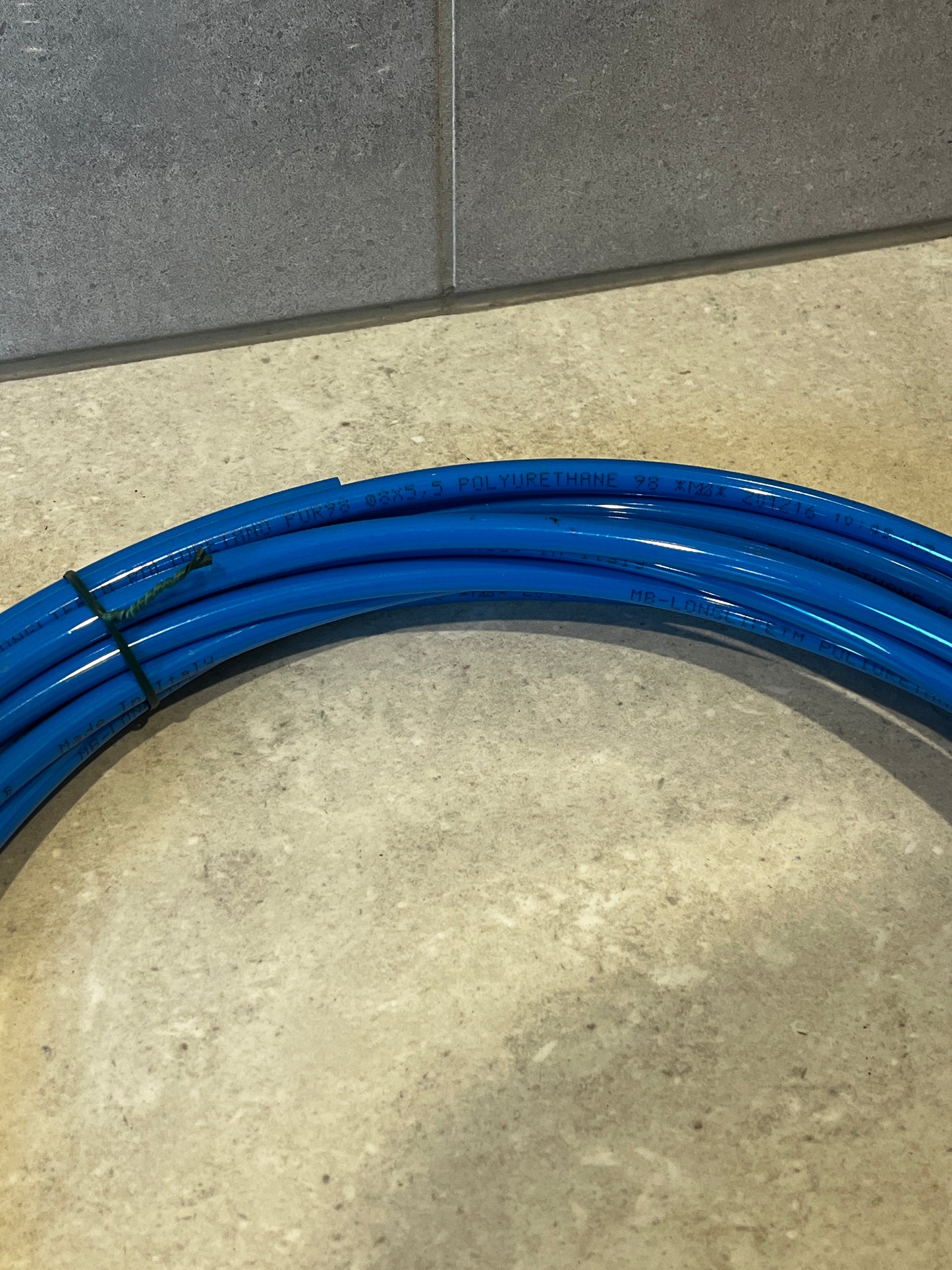 Detailed view of blue polyurethane tubing coil with printed technical details
