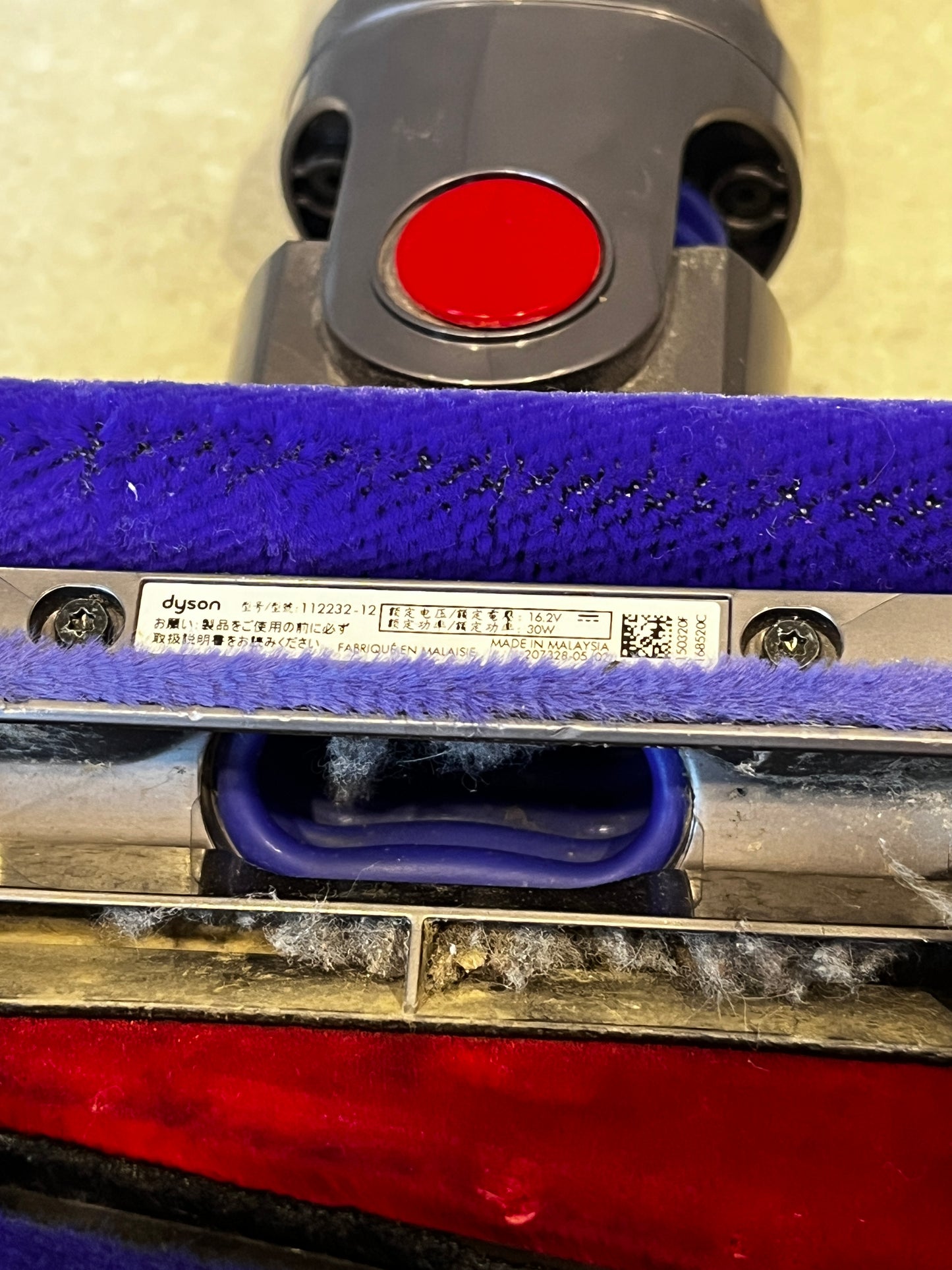 Close-up of Dyson vacuum brush head label and fabric roller with dust