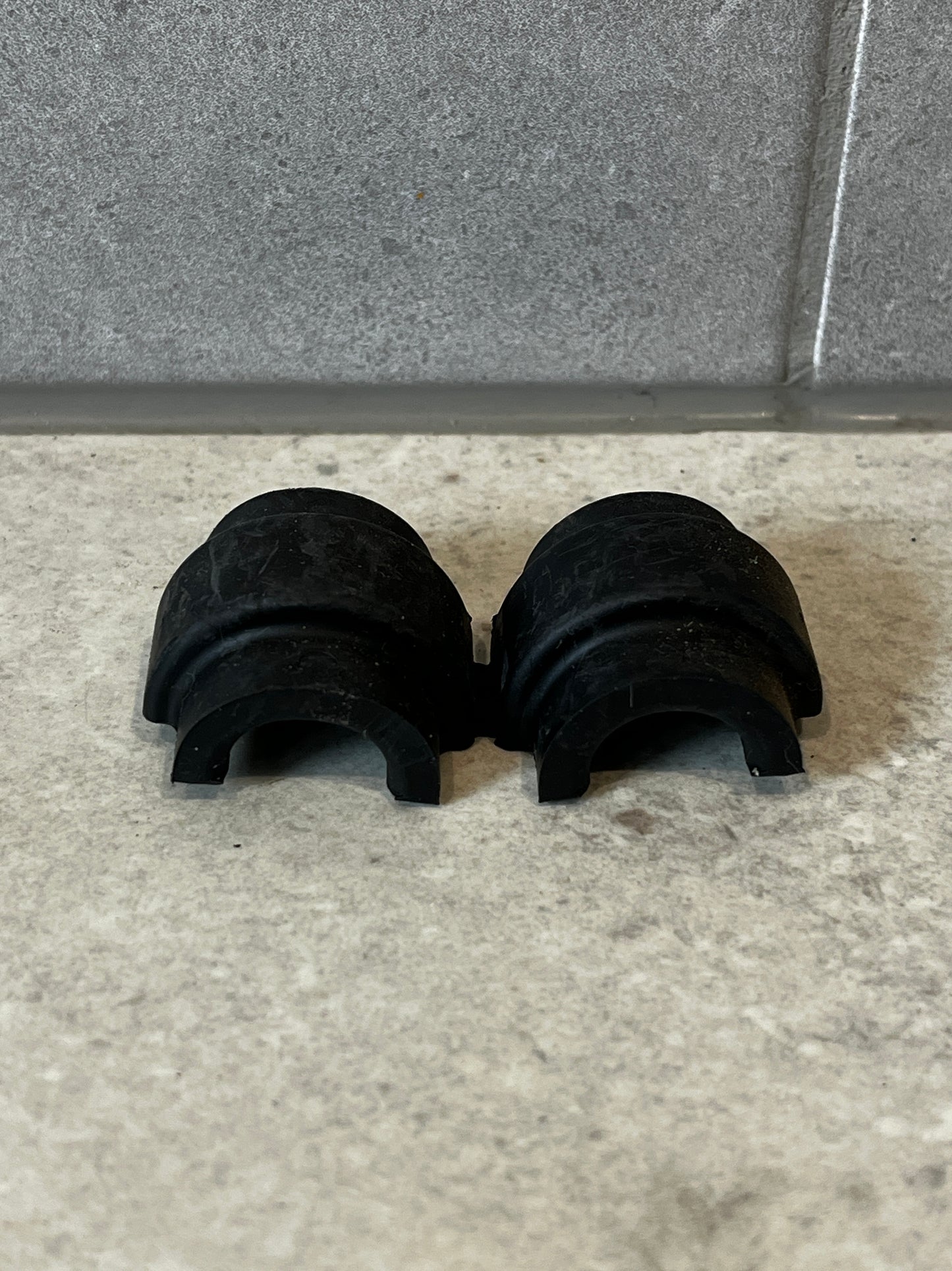 Top view of two black 15mm pipe clamps with curved grip design