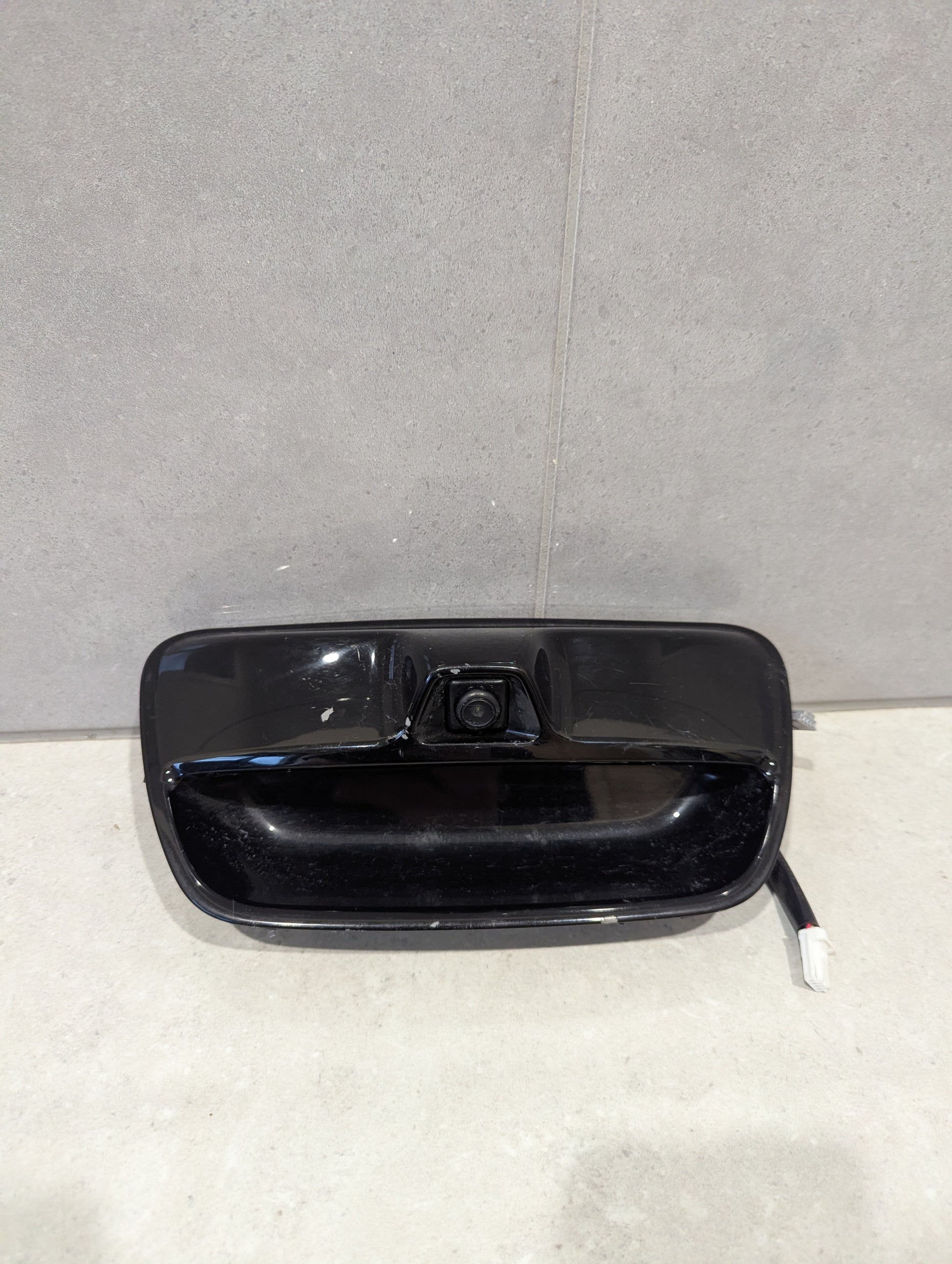 Front view of rear view camera tailgate handle assembly with black finish and integrated camera