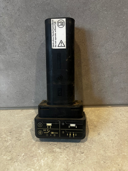Black plastic electrical connector standing upright with safety instructions on label