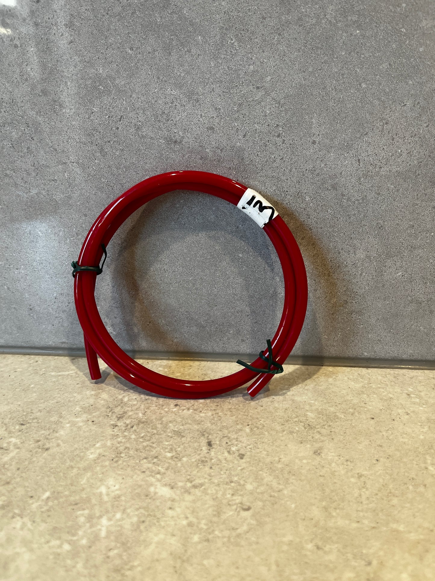 Coiled red flexible tubing on a flat surface