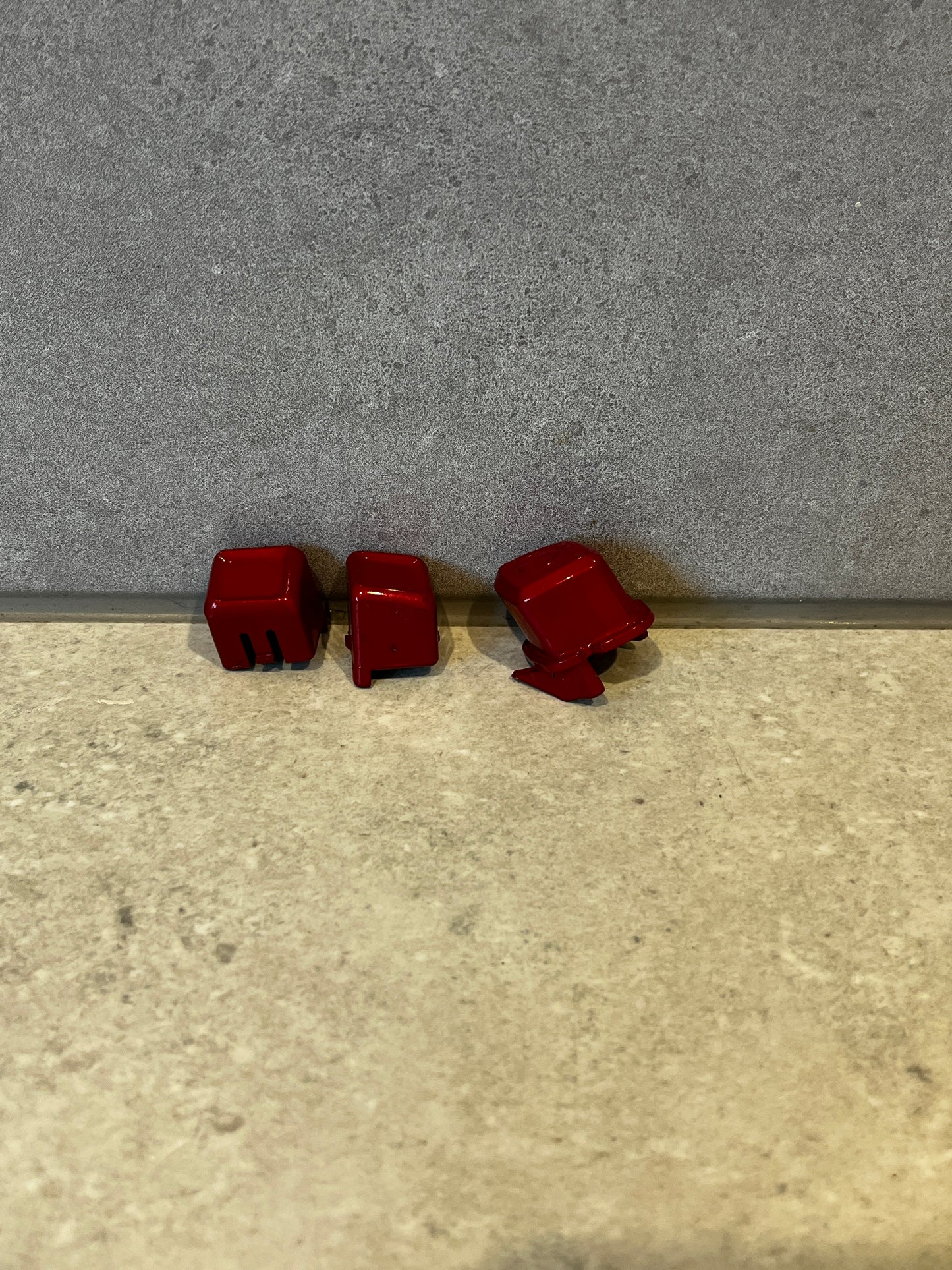 Set of three red mechanical keyboard keycaps viewed from various angles