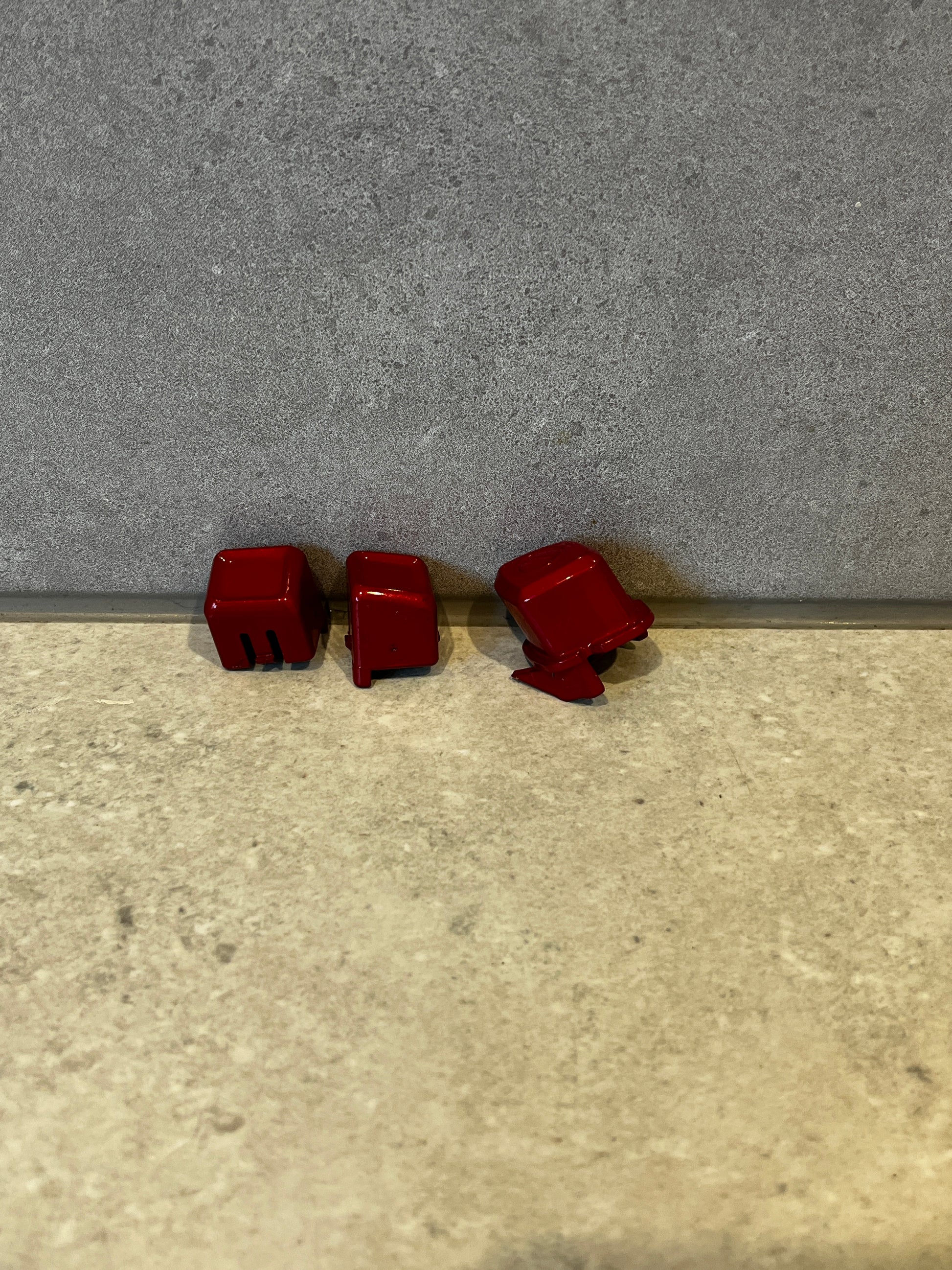 Set of three red mechanical keyboard keycaps viewed from various angles