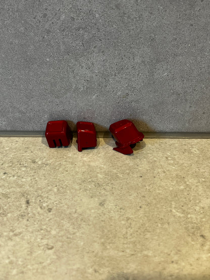 Set of three red mechanical keyboard keycaps viewed from various angles