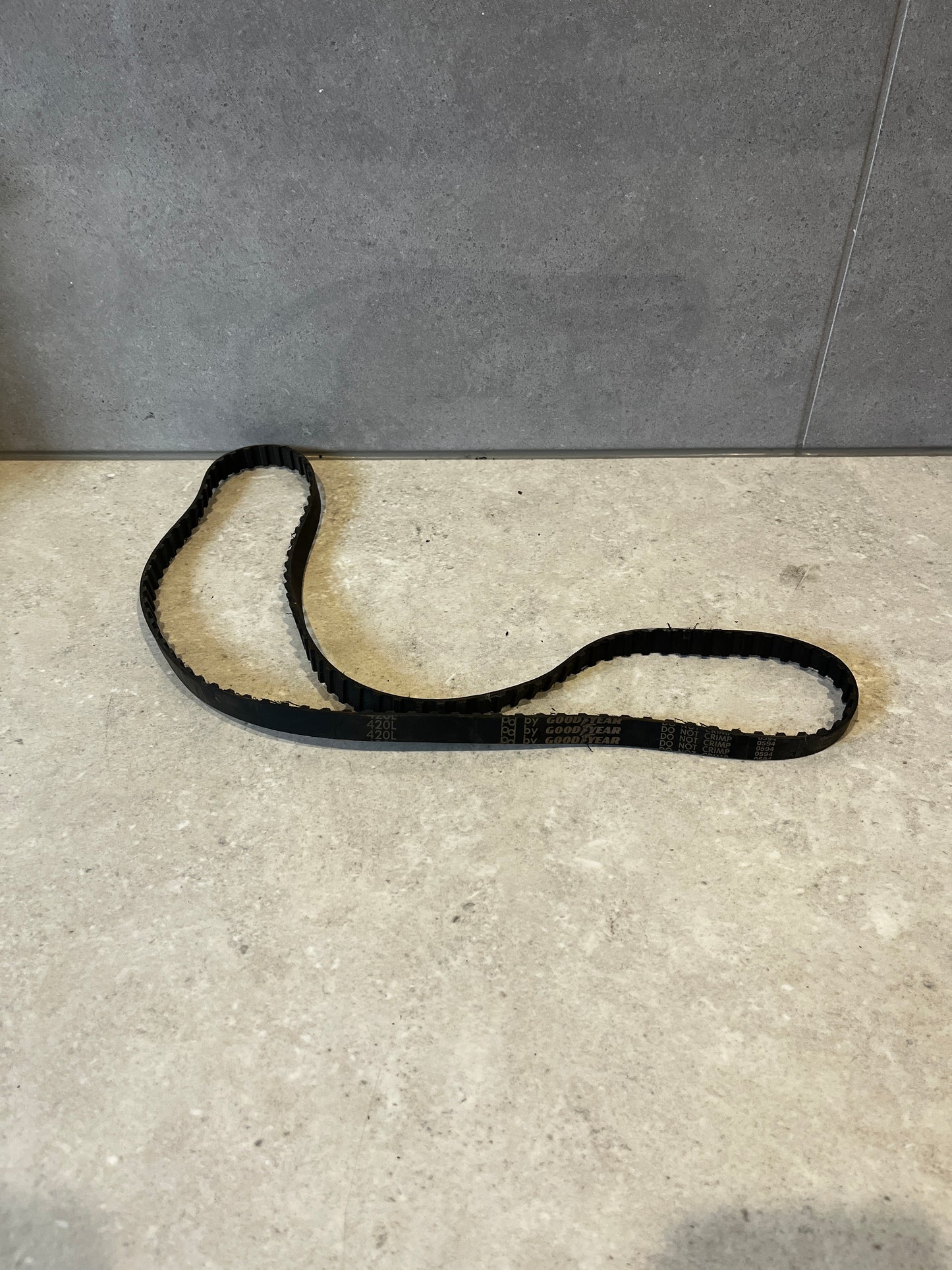 Goodyear 420L timing belt laid out on a stone surface