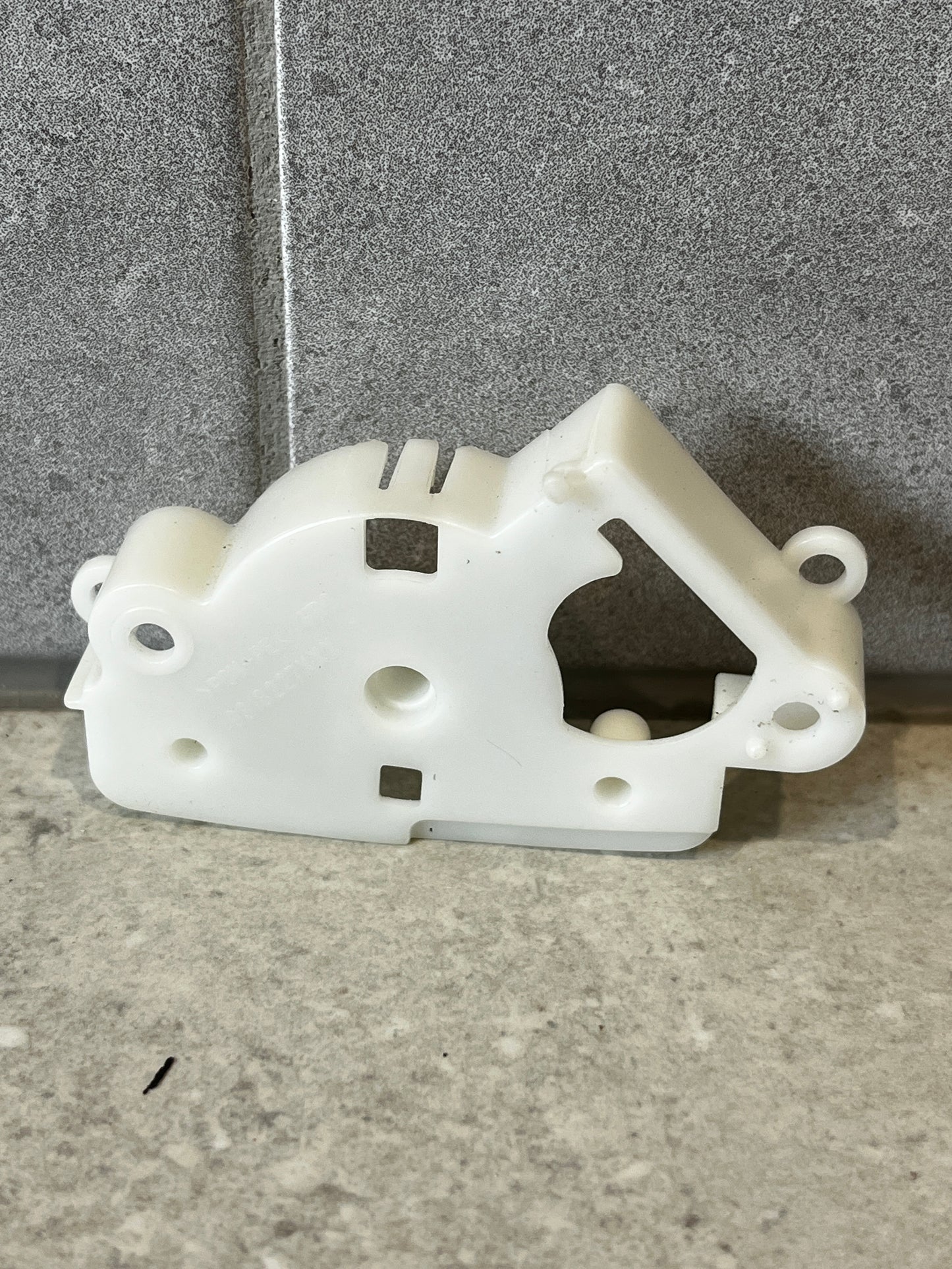 Front view of white plastic mechanical lever bracket on stone background