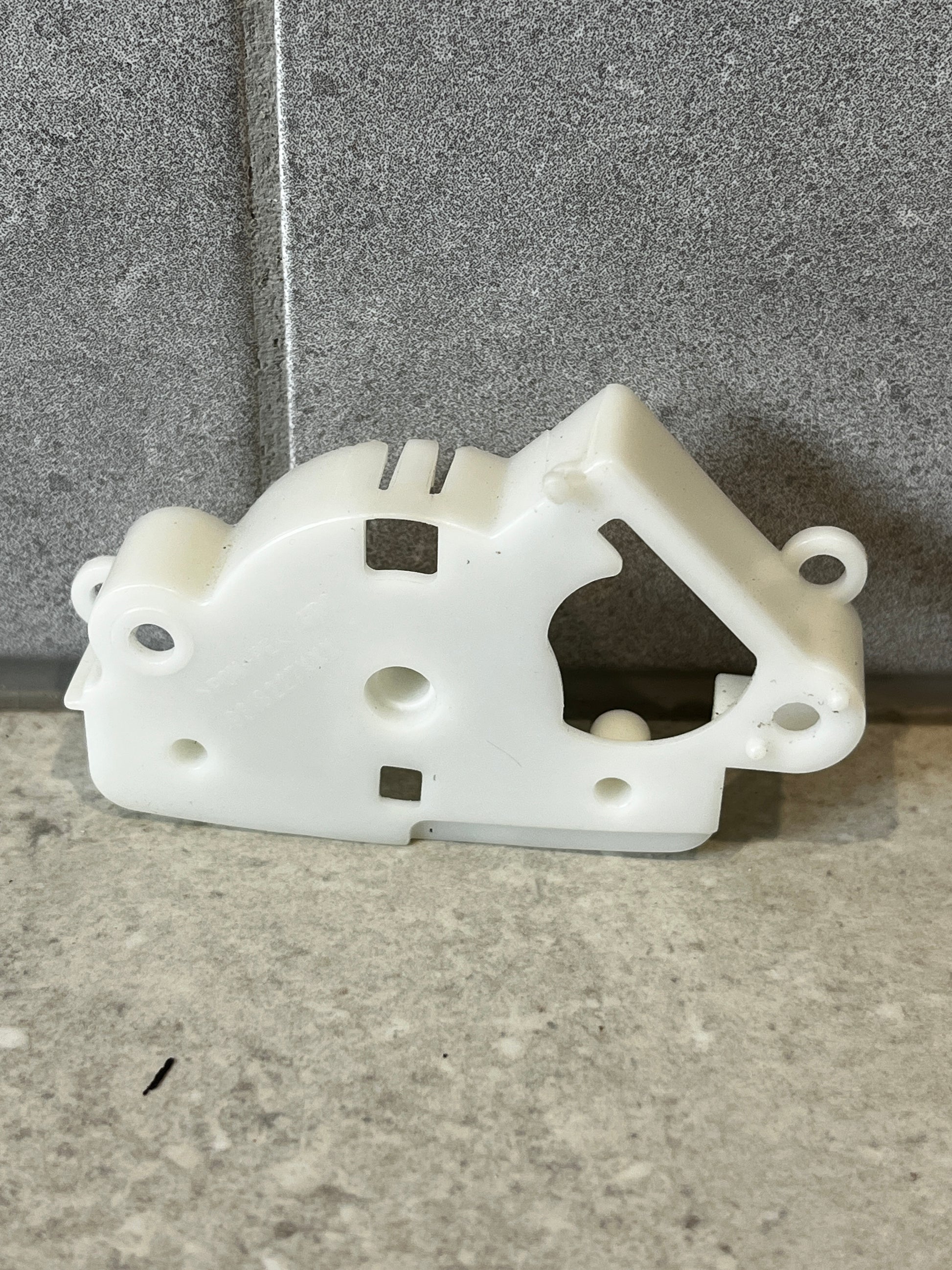 Front view of white plastic mechanical lever bracket on stone background