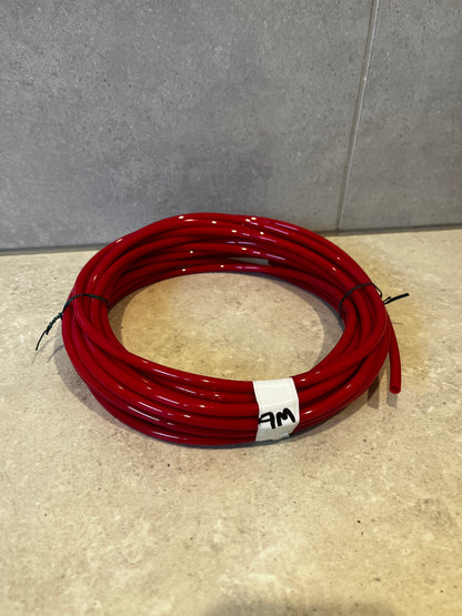 Coiled red polyurethane tubing placed on a beige surface