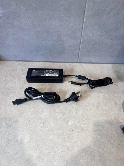 HP laptop power adapter and power cord set on a counter
