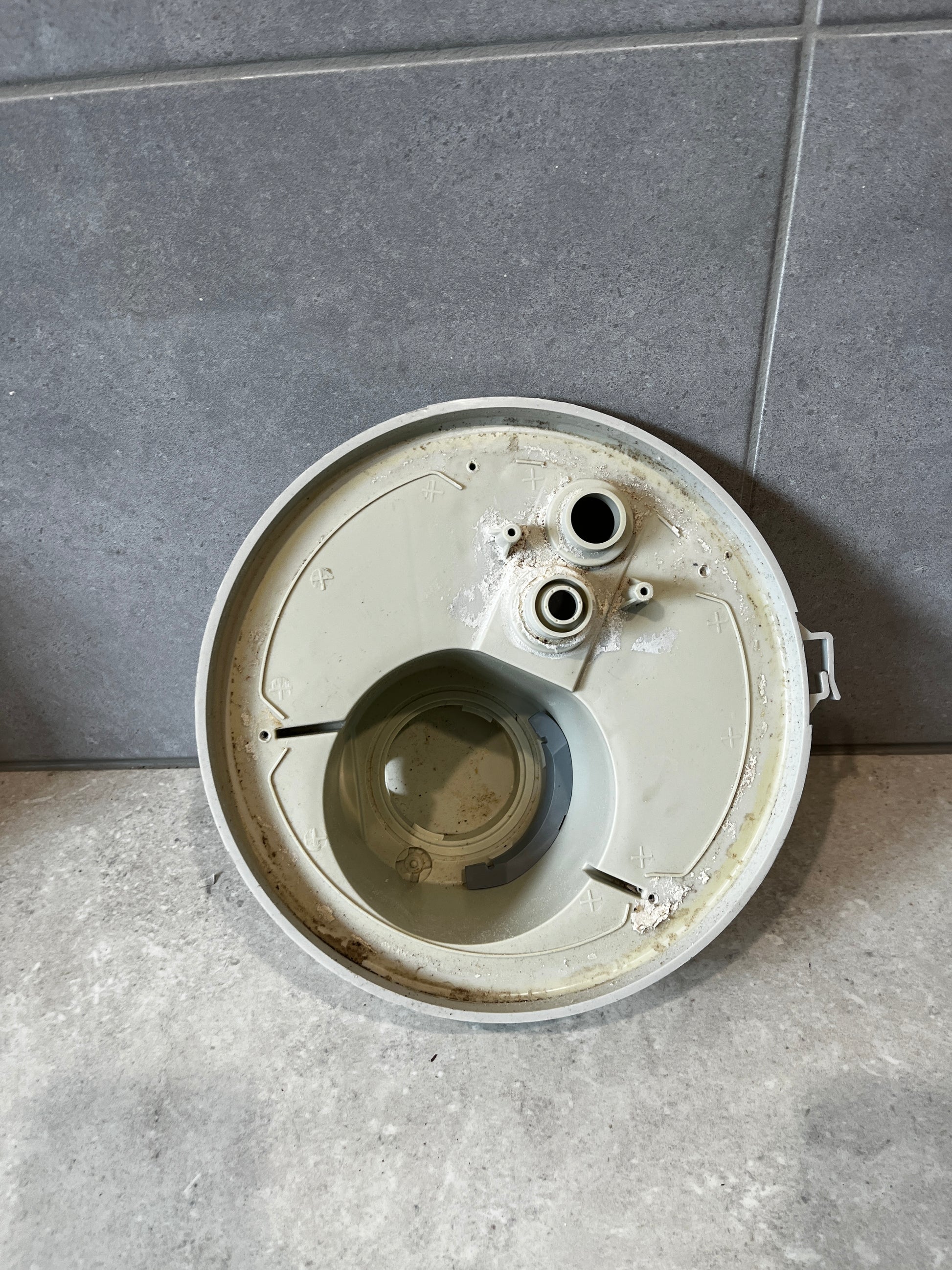 Top view of round plastic pump filter housing with ports and internal compartment