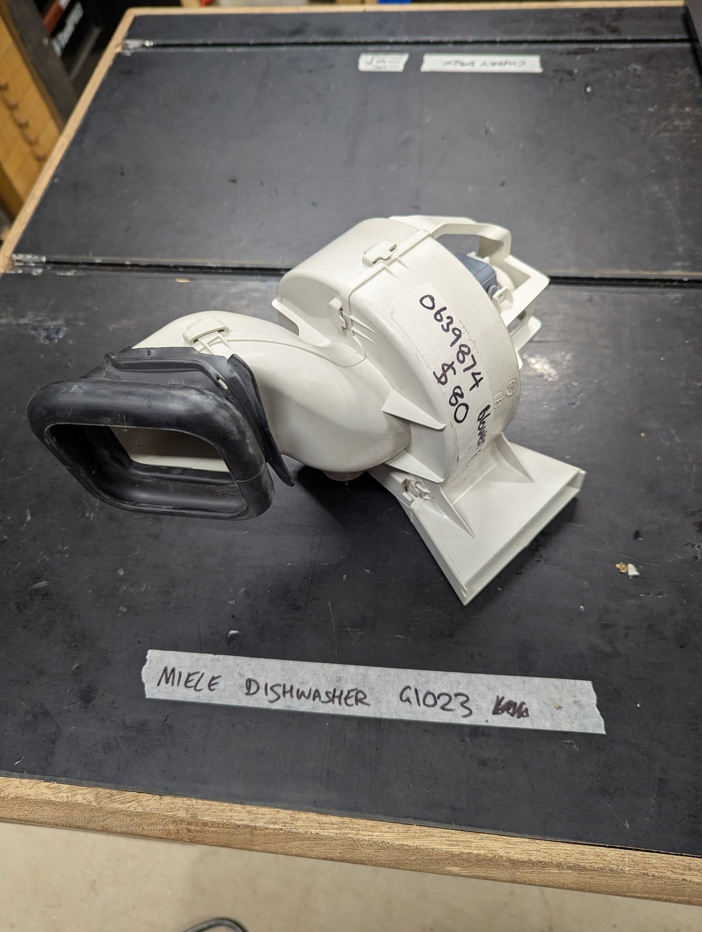 Close-up of Miele G1023 dishwasher blower assembly replacement part on a clean surface