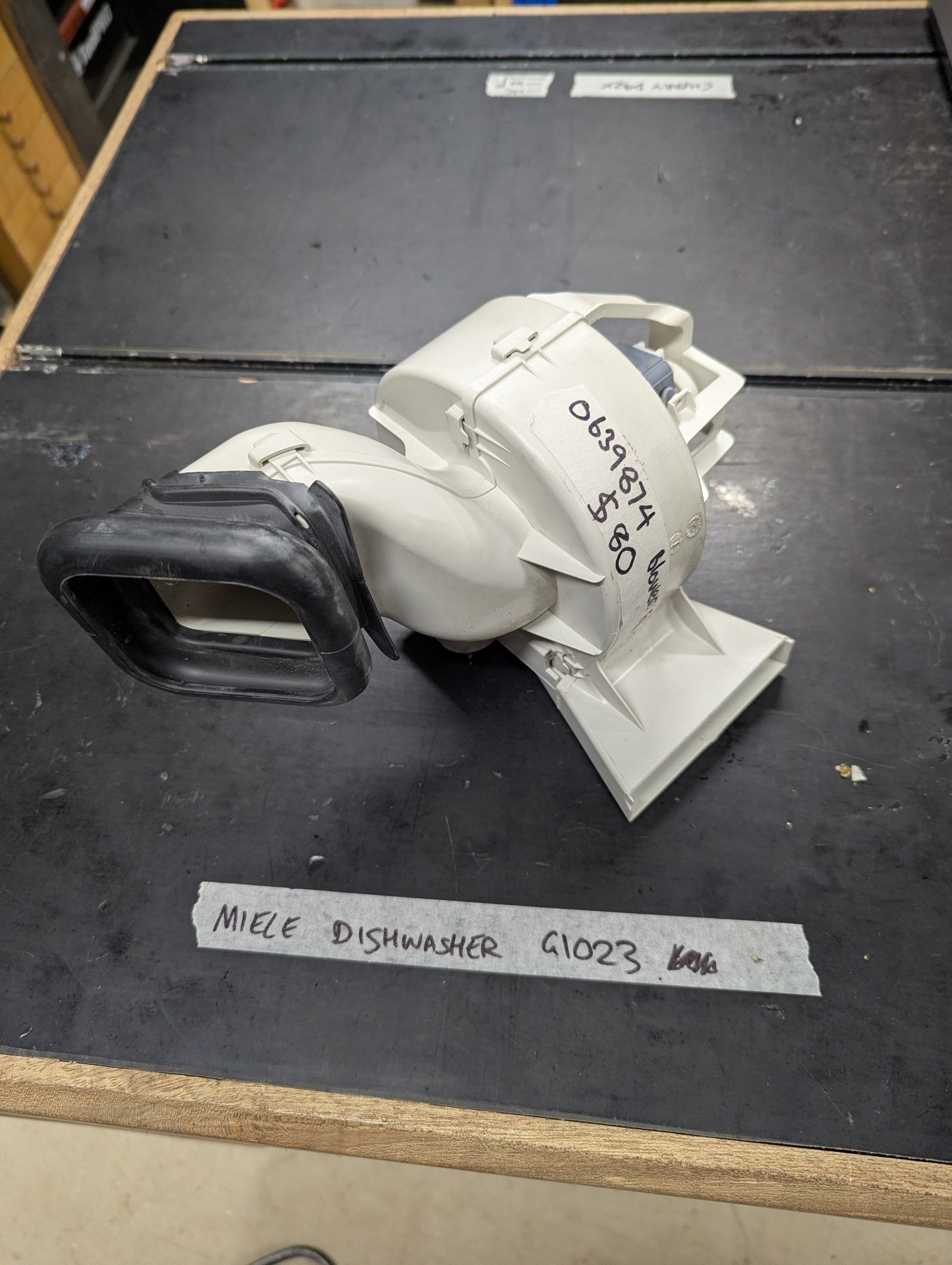 Close-up of Miele G1023 dishwasher blower assembly replacement part on a clean surface