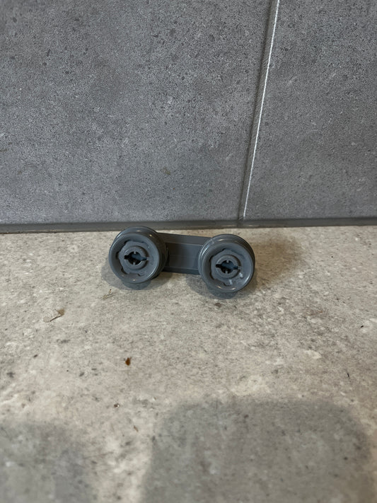 Gray dishwasher rack roller wheel assembly on tile background