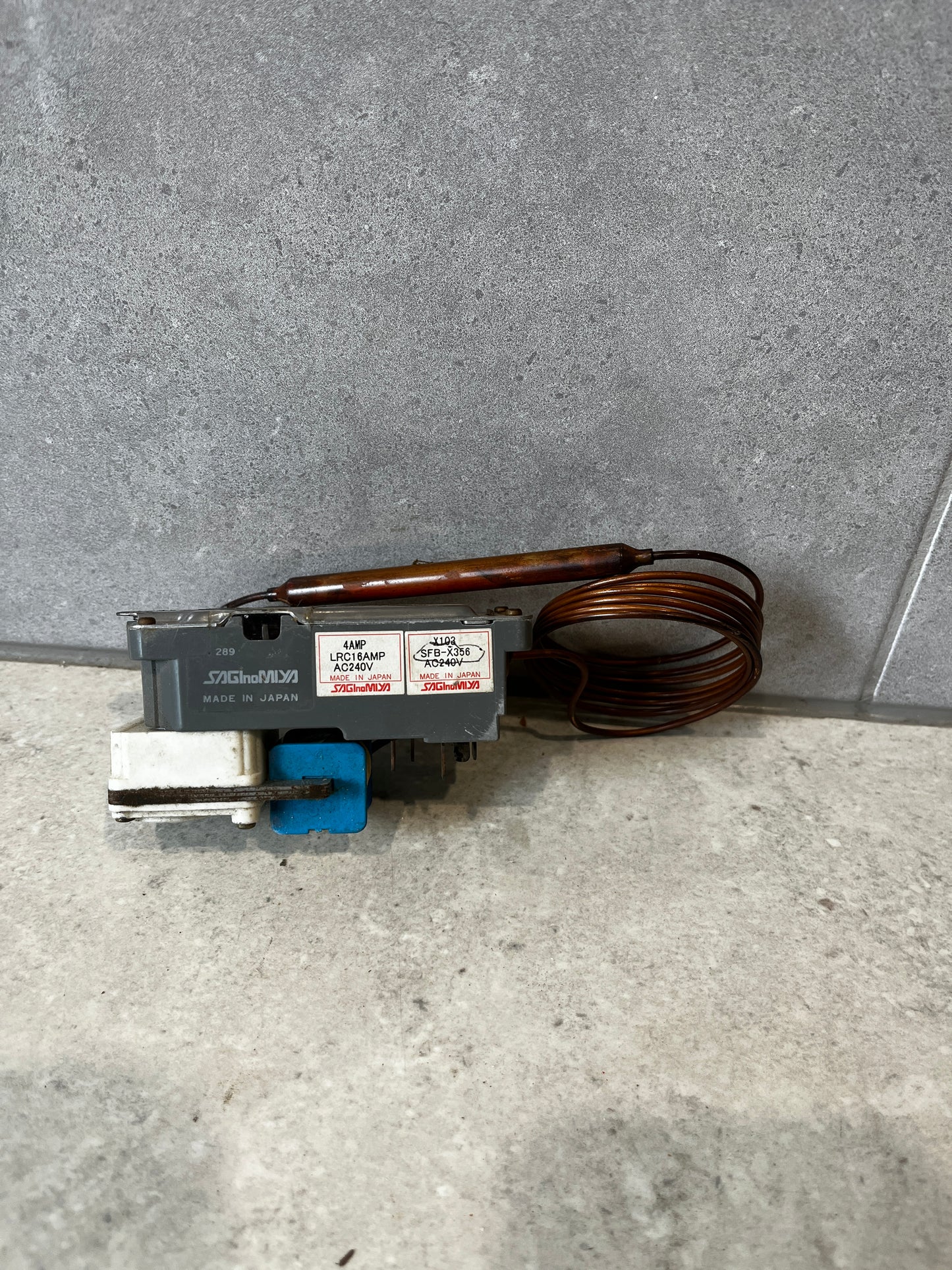Saginomiya capillary thermostat switch unit with coil on gray surface