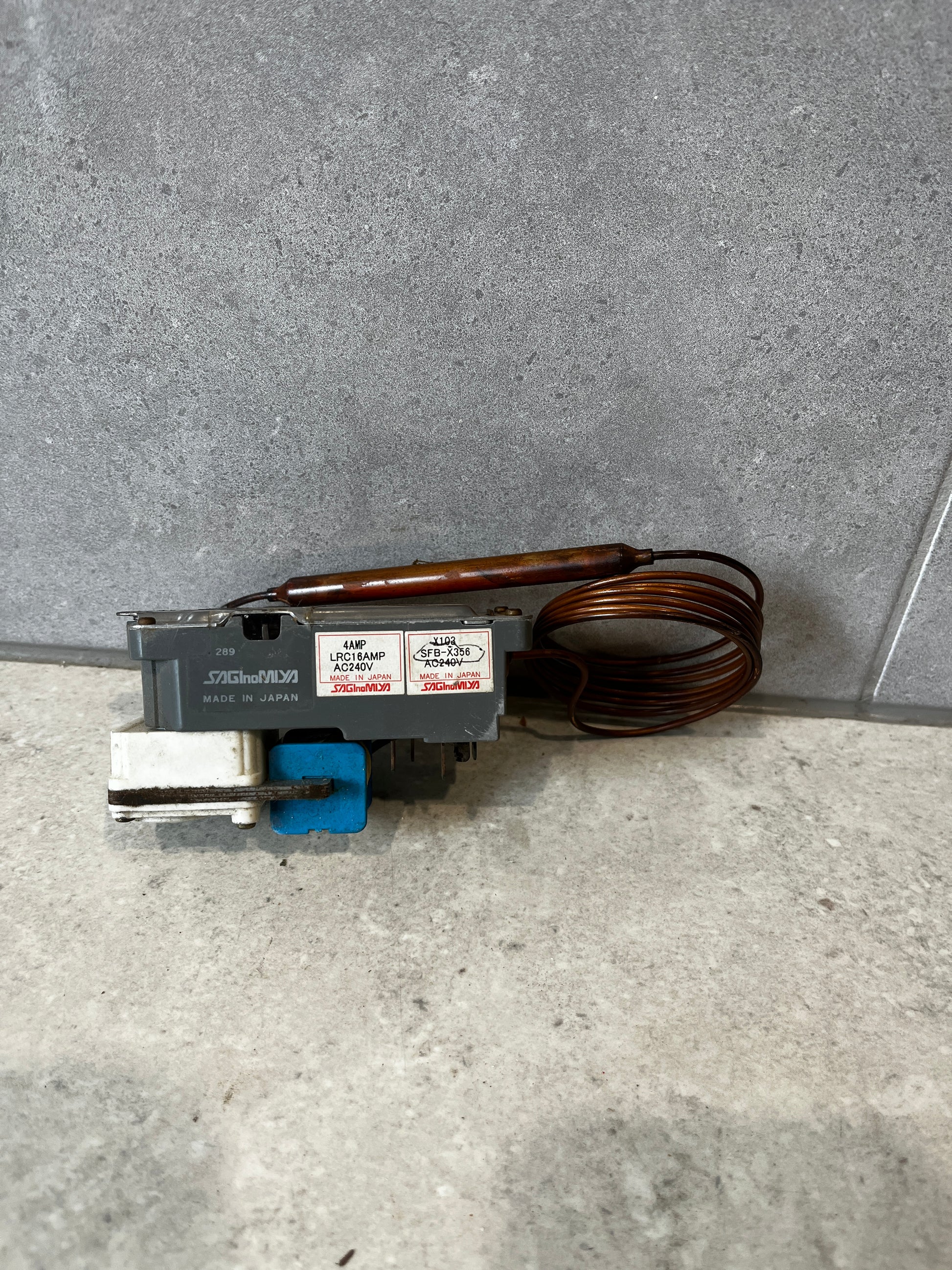 Saginomiya capillary thermostat switch unit with coil on gray surface