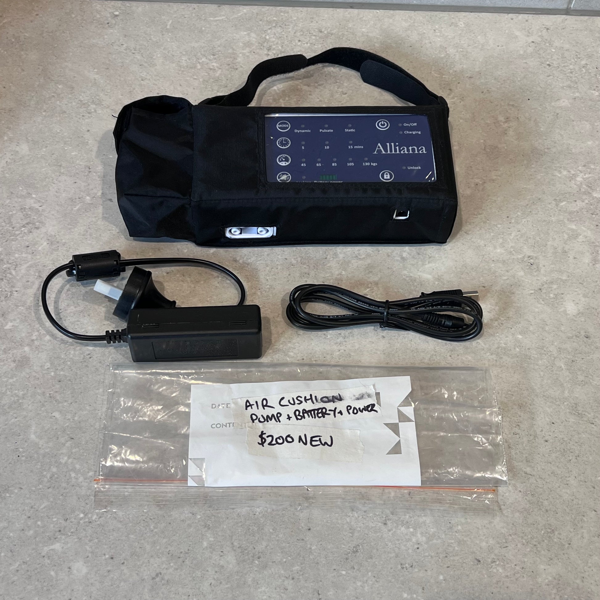 Alliana air cushion pump set with control unit, charger, and power cable on counter