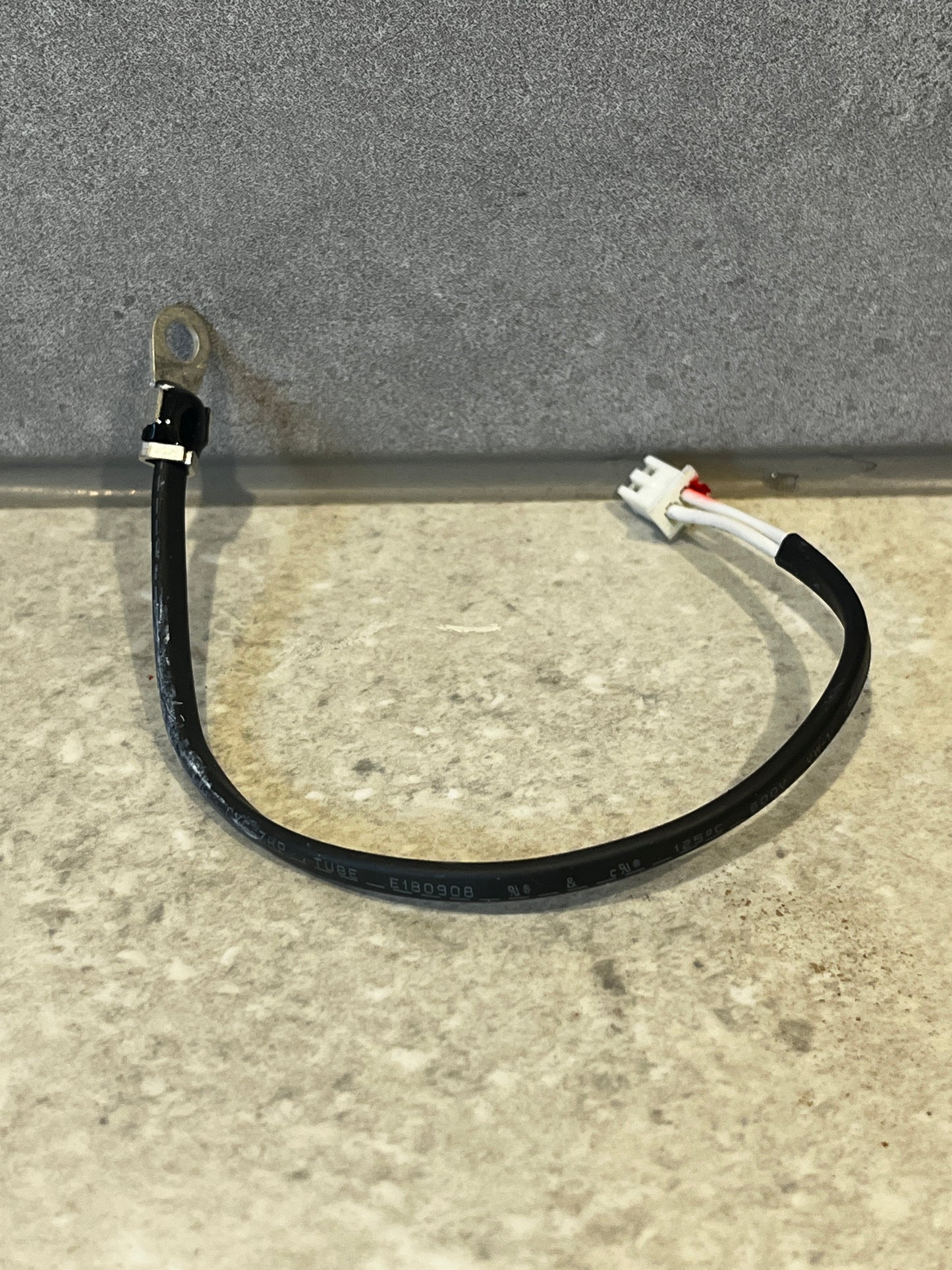 Cable with ring terminal and 2-pin plastic connector on a countertop