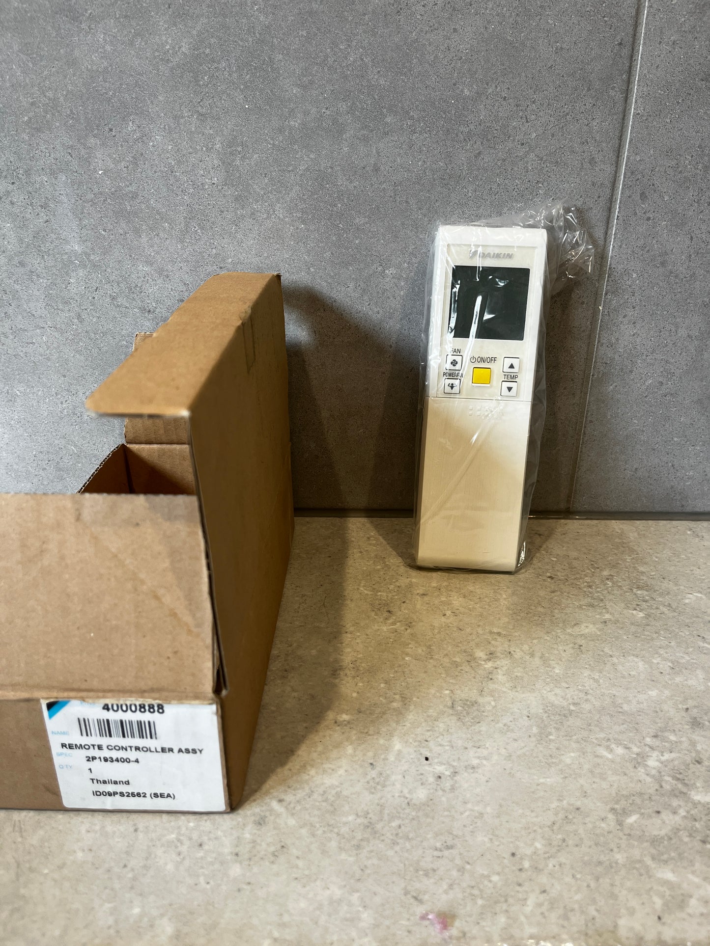 Daikin remote controller assembly with original box on a gray surface