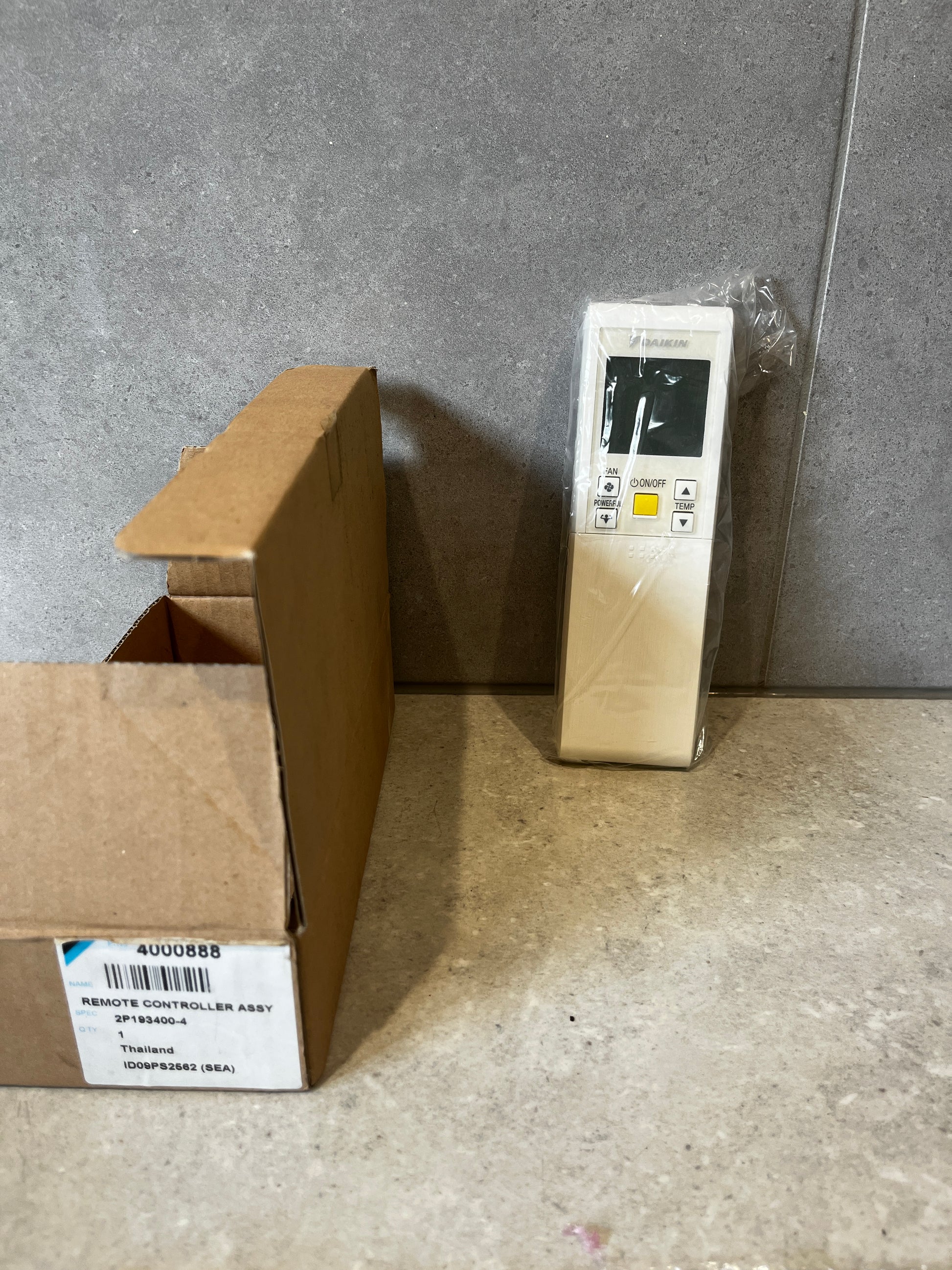 Daikin remote controller assembly with original box on a gray surface